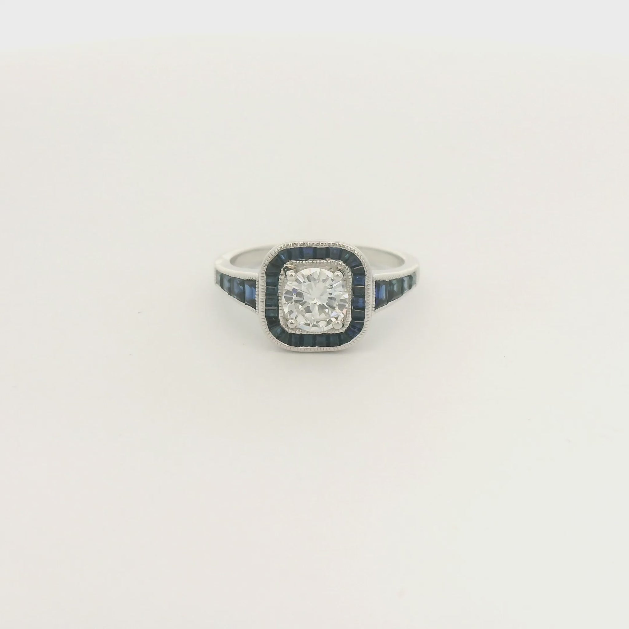 A White Gold Ring with a prong set round cut natural Diamond in the center with a halo of baguette cut blue sapphires and sapphires down shank at Forever Rox Fine Jewelry, Lake Tahoes Best Jewelry Store
