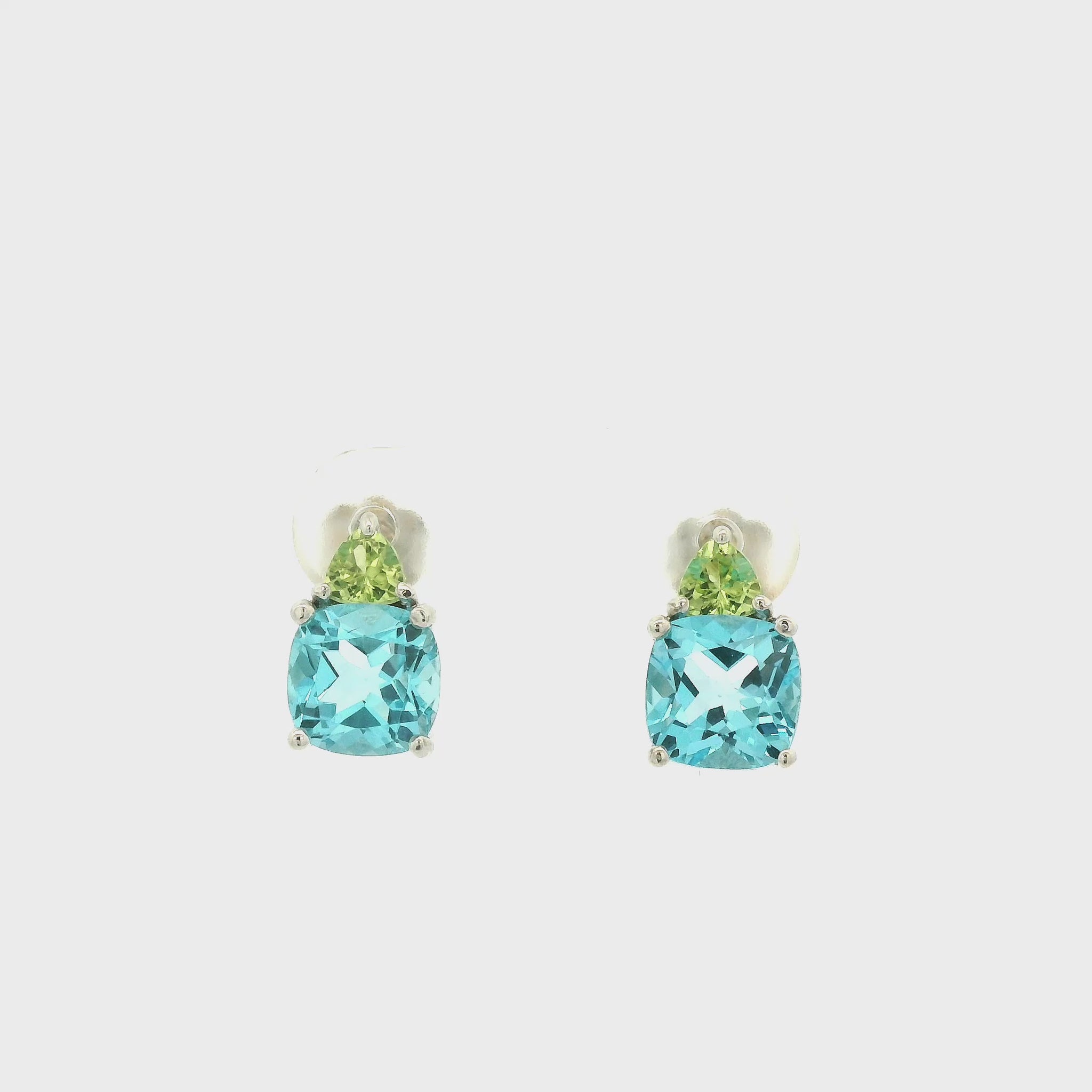 A Pair of White Gold Stud Earrings with prong set fancy cushion cut natural Blue Topaz and triangle cut peridot at Forever Rox Fine Jewelry, Lake Tahoes Best Jewelry Store