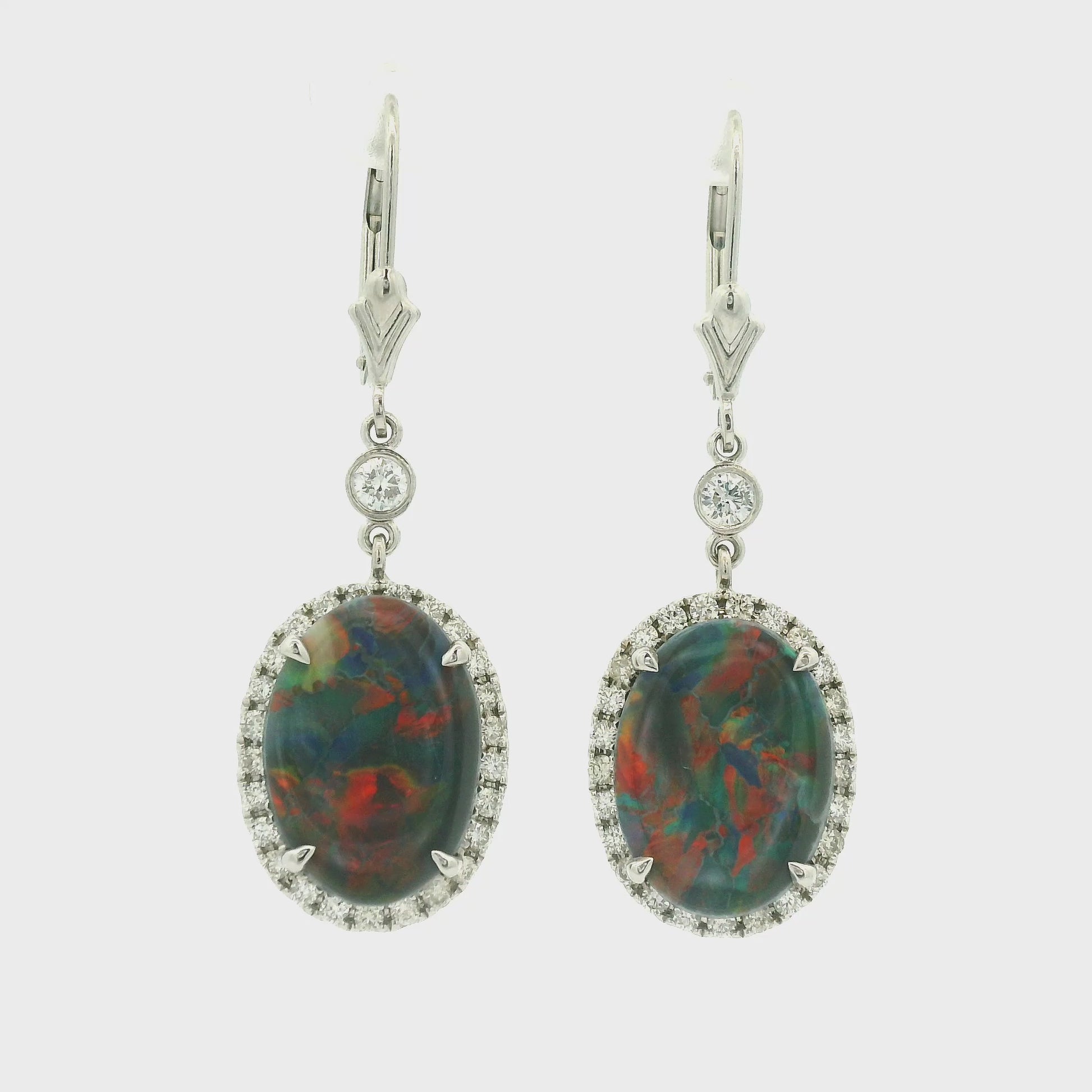 A Pair of White Gold Earrings with prong set oval cut natural Black Lightning Ridge Opals in the center with a diamond halo at Forever Rox Fine Jewelry, Lake Tahoes Best Jewelry Store