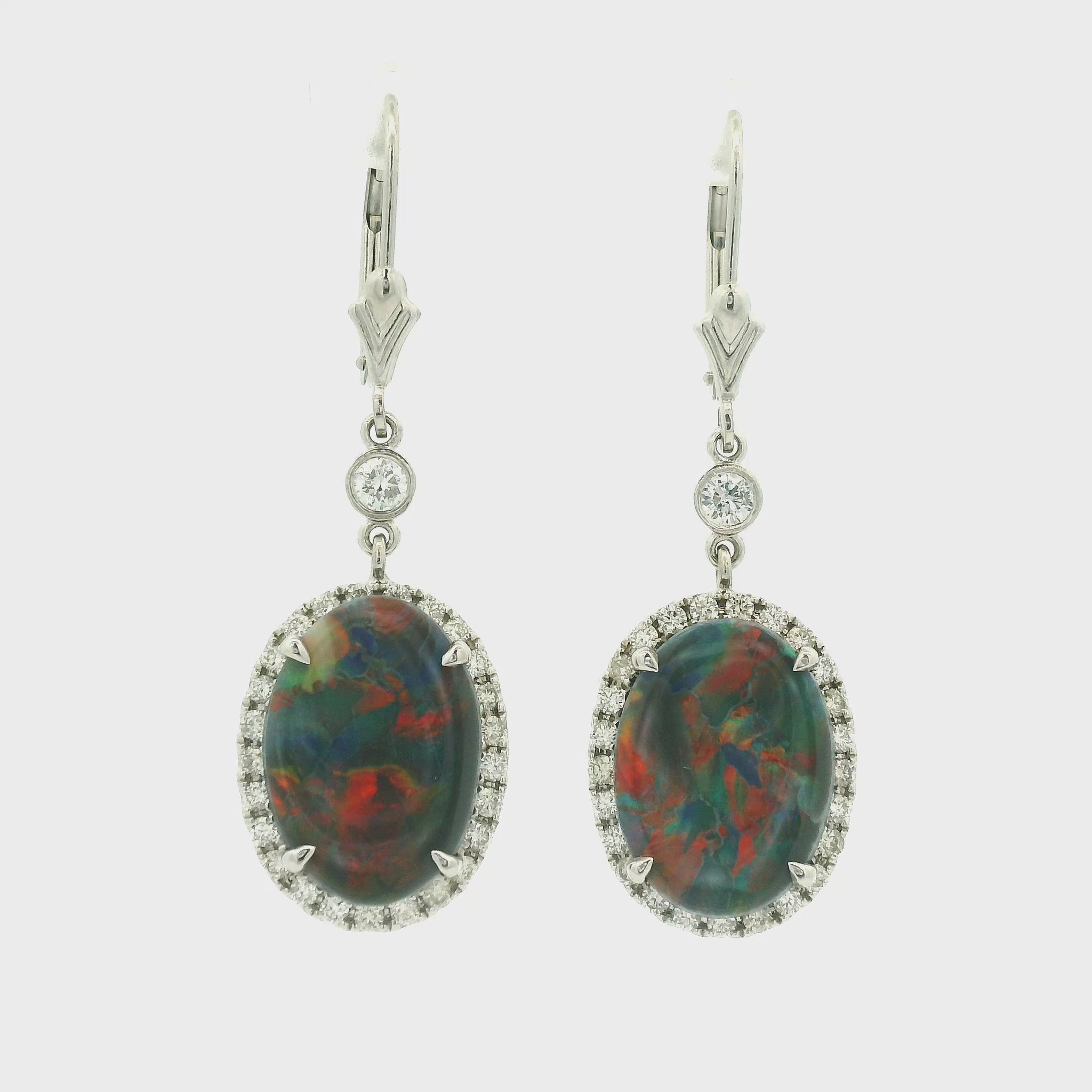 A Pair of White Gold Earrings with prong set oval cut natural Black Lightning Ridge Opals in the center with a diamond halo at Forever Rox Fine Jewelry, Lake Tahoes Best Jewelry Store