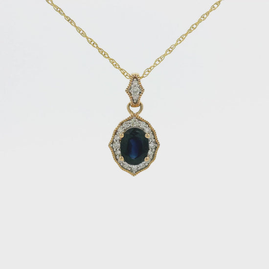 A Yellow Gold Pendant with a prong set oval cut natural Sapphire in the center with a halo of diamonds and miltgrain design bezel with a diamond bail at Forever Rox Fine Jewelry, Lake Tahoes Best Jewelry Store