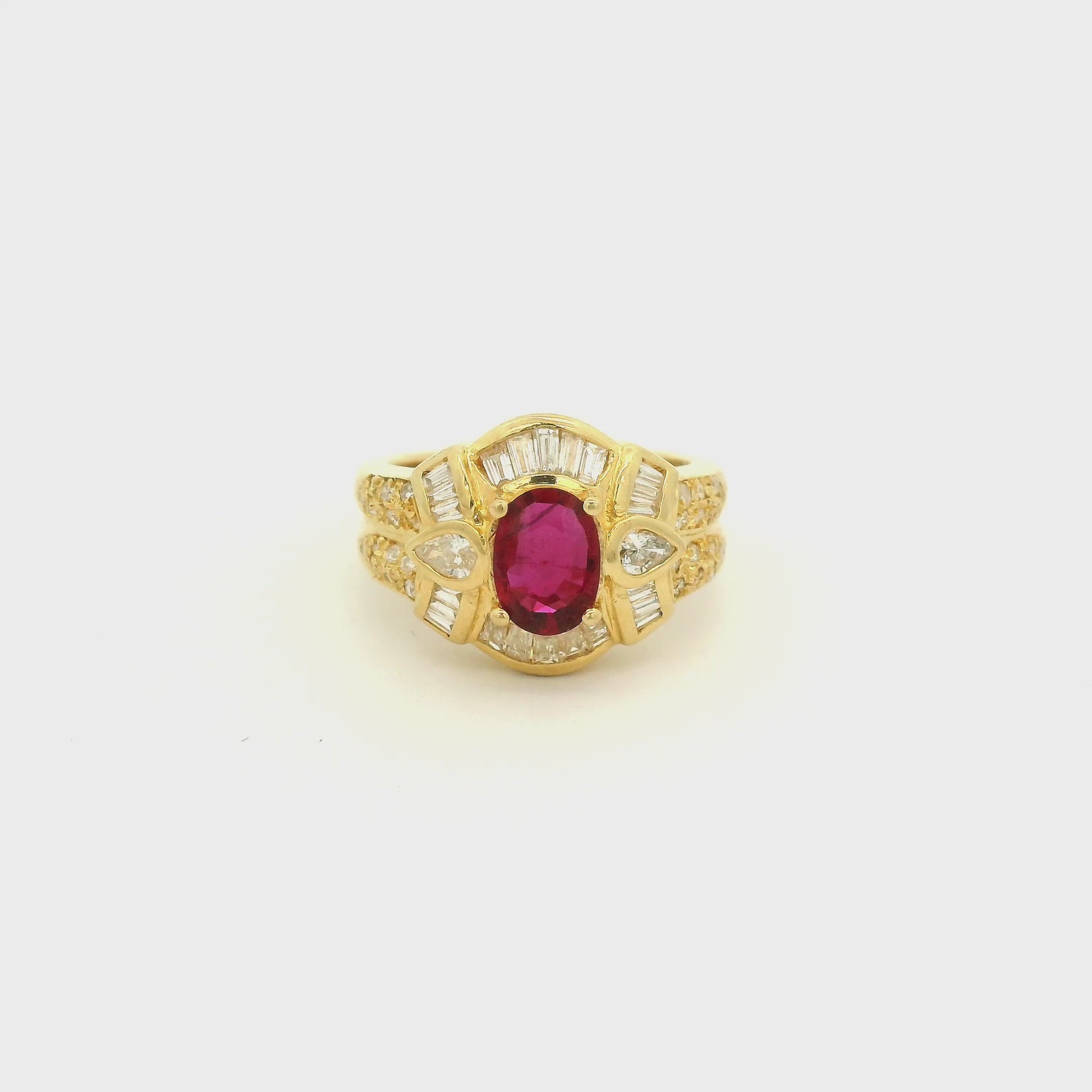 A Yellow Gold Ring with a prong set oval cut natural Ruby in the center with baguette, pear and round cut diamonds around it at Forever Rox Fine Jewelry, Lake Tahoes Best Jewelry Store