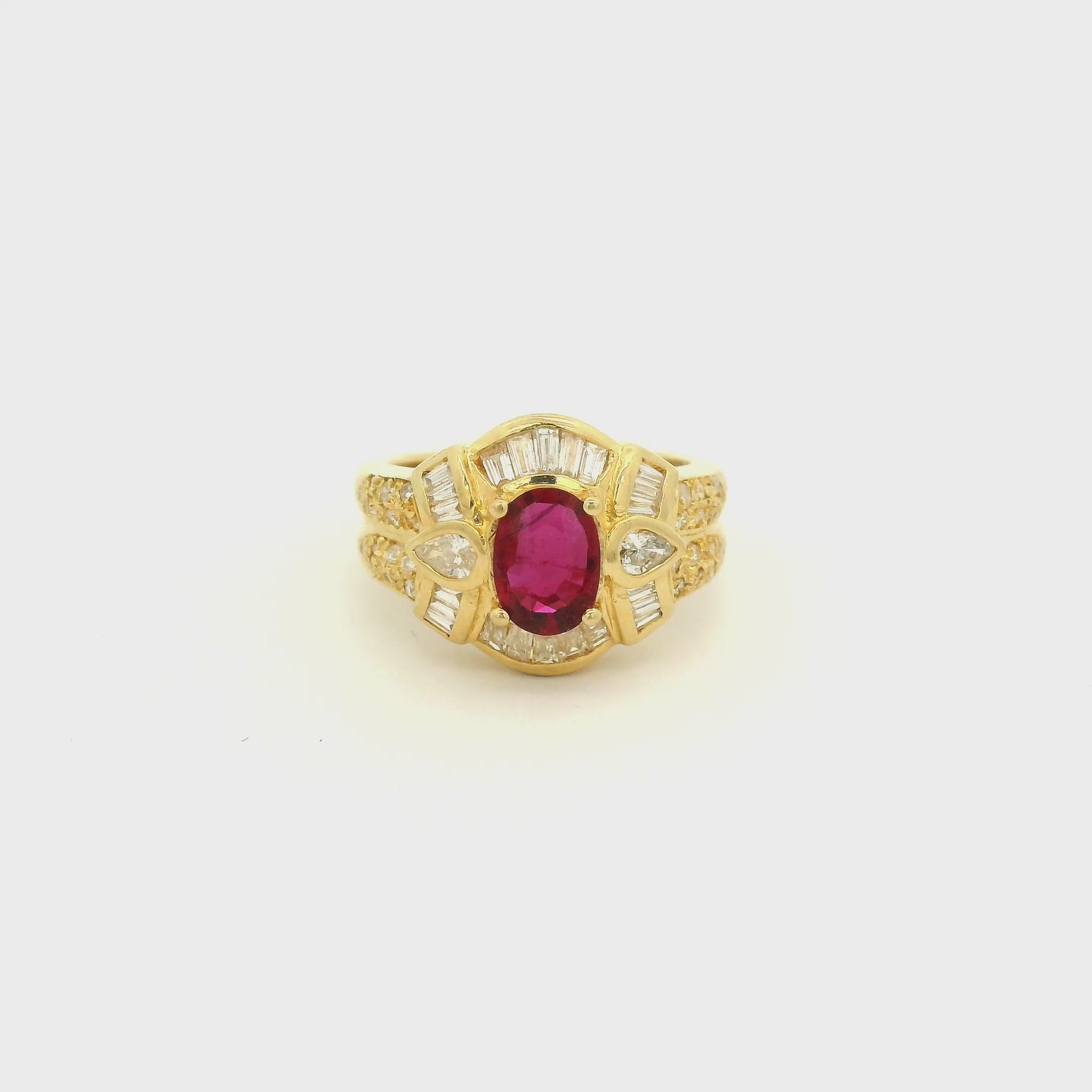 A Yellow Gold Ring with a prong set oval cut natural Ruby in the center with baguette, pear and round cut diamonds around it at Forever Rox Fine Jewelry, Lake Tahoes Best Jewelry Store