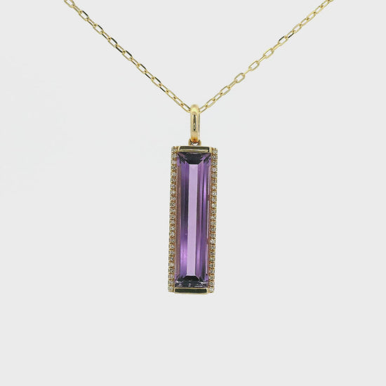 A Yellow Gold Pendant with a long prong set emerald cut natural Amethyst in the center with a hot of diamonds at Forever Rox Fine Jewelry, Lake Tahoes Best Jewelry Store

