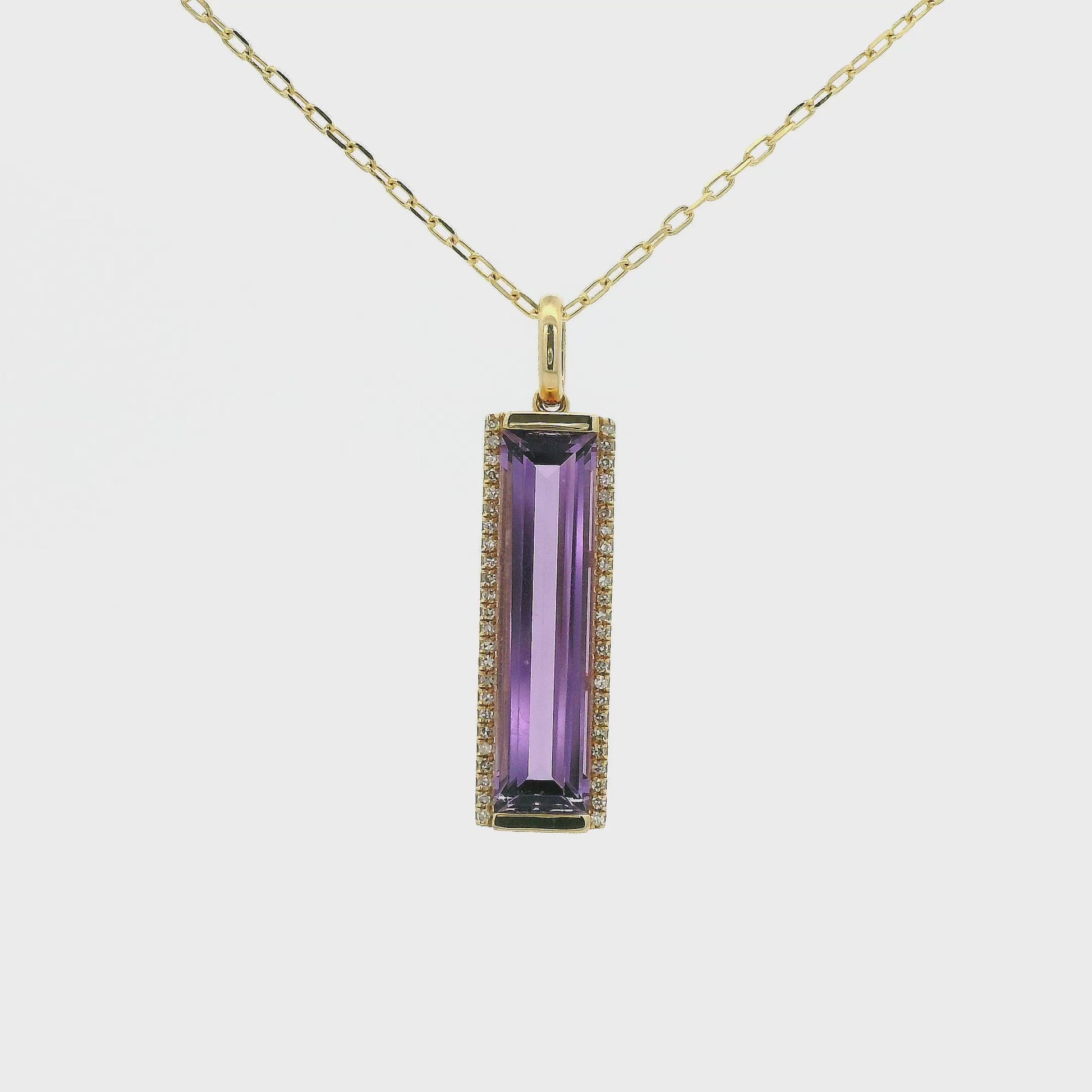 A Yellow Gold Pendant with a long prong set emerald cut natural Amethyst in the center with a hot of diamonds at Forever Rox Fine Jewelry, Lake Tahoes Best Jewelry Store
