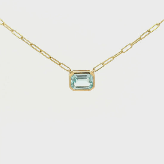 A Yellow Gold Pendant with a bezel set emerald cut natural Swiss Blue Topaz in the center with a paperclip chain attached at Forever Rox Fine Jewelry, Lake Tahoes Best Jewelry Store
