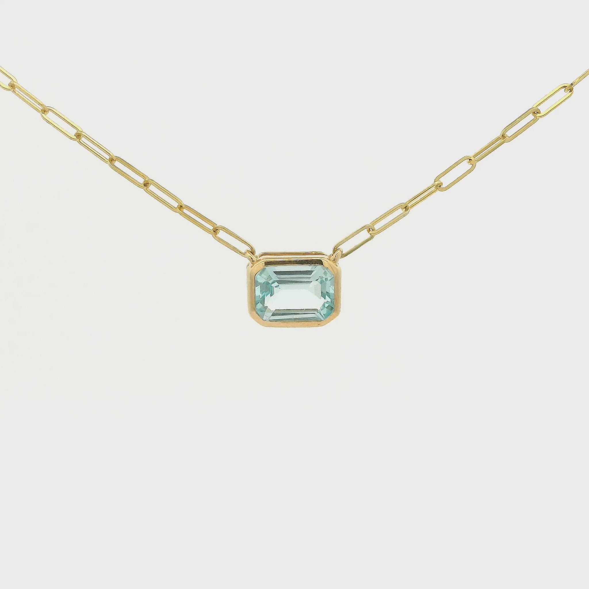 A Yellow Gold Pendant with a bezel set emerald cut natural Swiss Blue Topaz in the center with a paperclip chain attached at Forever Rox Fine Jewelry, Lake Tahoes Best Jewelry Store
