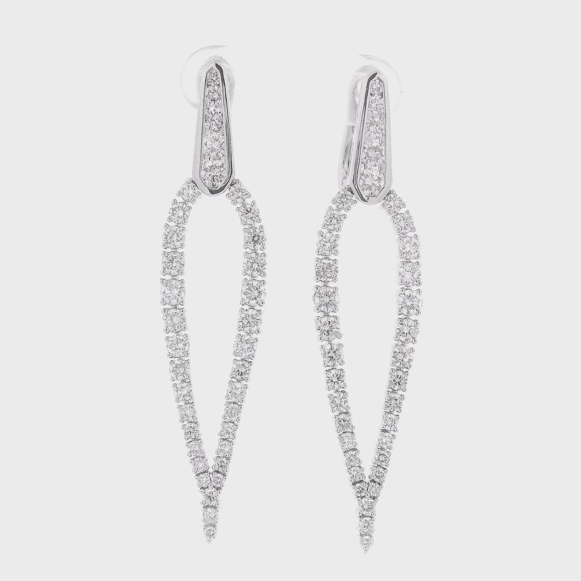 A Pair of White Gold Tear Drop Shape Dangles with a round cut Diamondscovering the earrings at Forever Rox Fine Jewelry, Lake Tahoes Best Jewelry Store