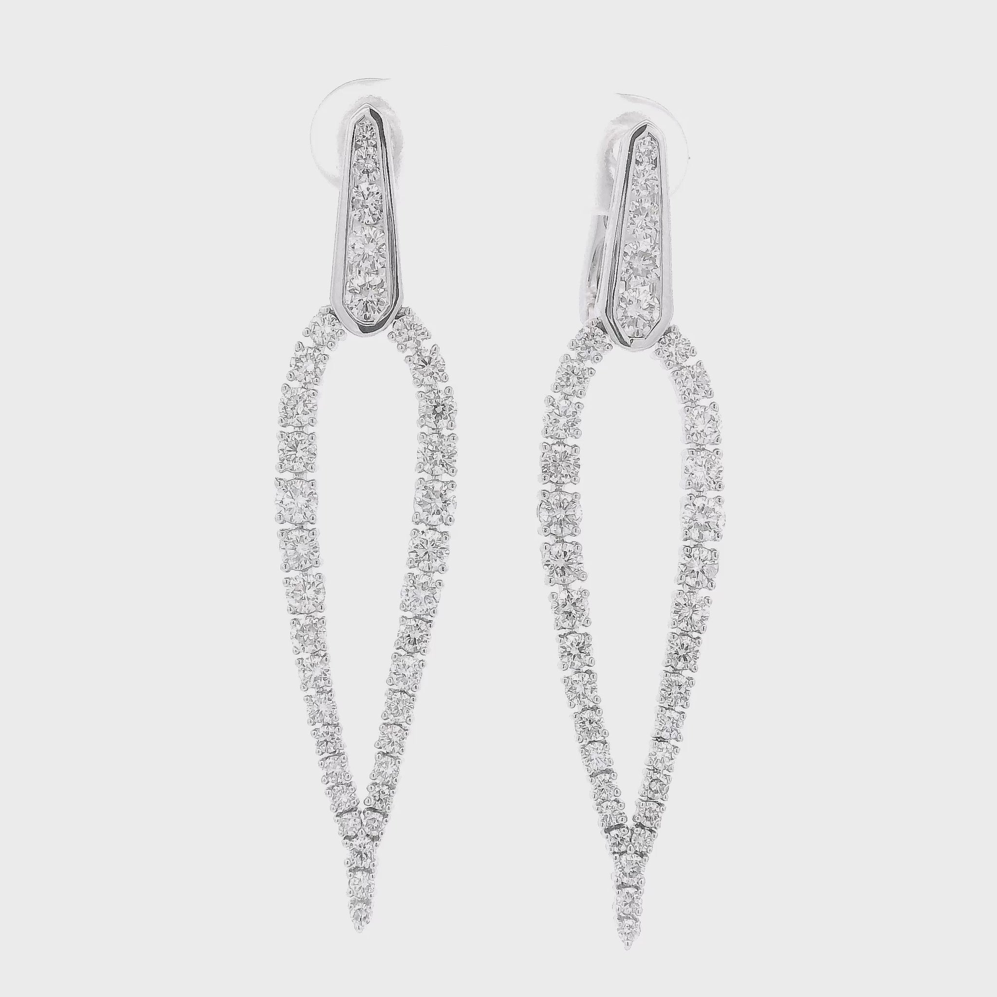 A Pair of White Gold Tear Drop Shape Dangles with a round cut Diamondscovering the earrings at Forever Rox Fine Jewelry, Lake Tahoes Best Jewelry Store