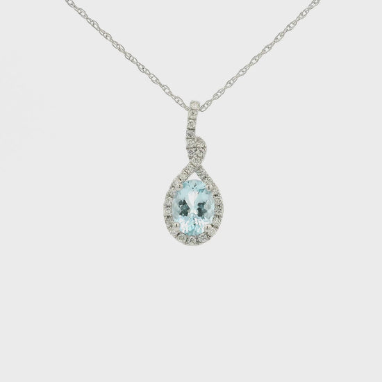 A White Gold Infinity Shaped Pendant with a prong set oval cut Aquamarine in the center with siamonds around the stone at Forever Rox Fine Jewelry, Lake Tahoes Best Jewelry Store