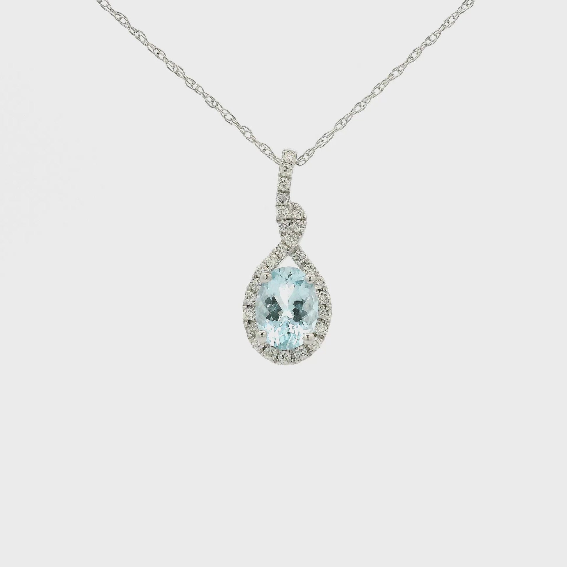 A White Gold Infinity Shaped Pendant with a prong set oval cut Aquamarine in the center with siamonds around the stone at Forever Rox Fine Jewelry, Lake Tahoes Best Jewelry Store