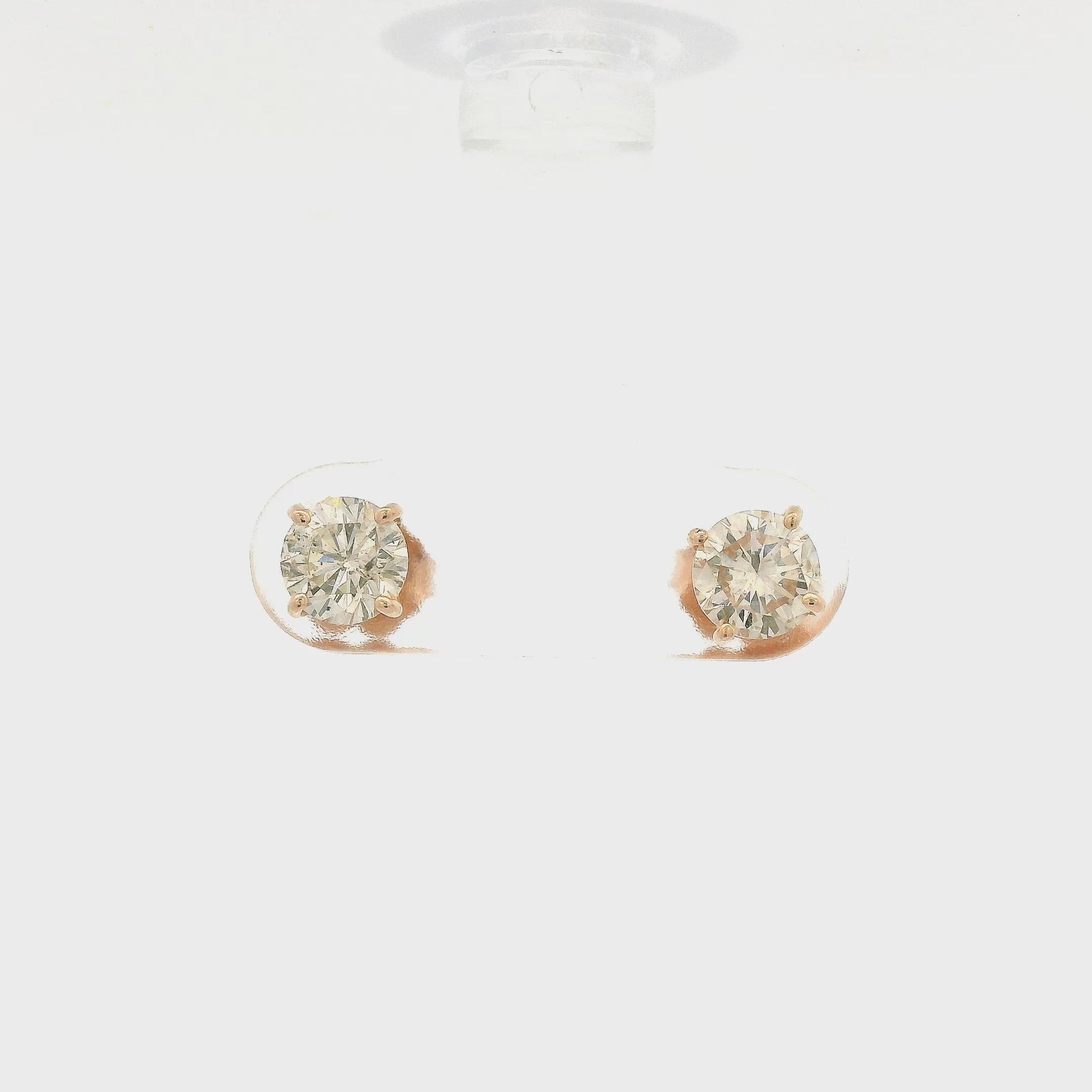 A Pair of round cut diamond studs with I1 clarity and totaling 1.10cts of diamonds set in 4 prong rose gold stud settings at Forever Rox Fine Jewelry
