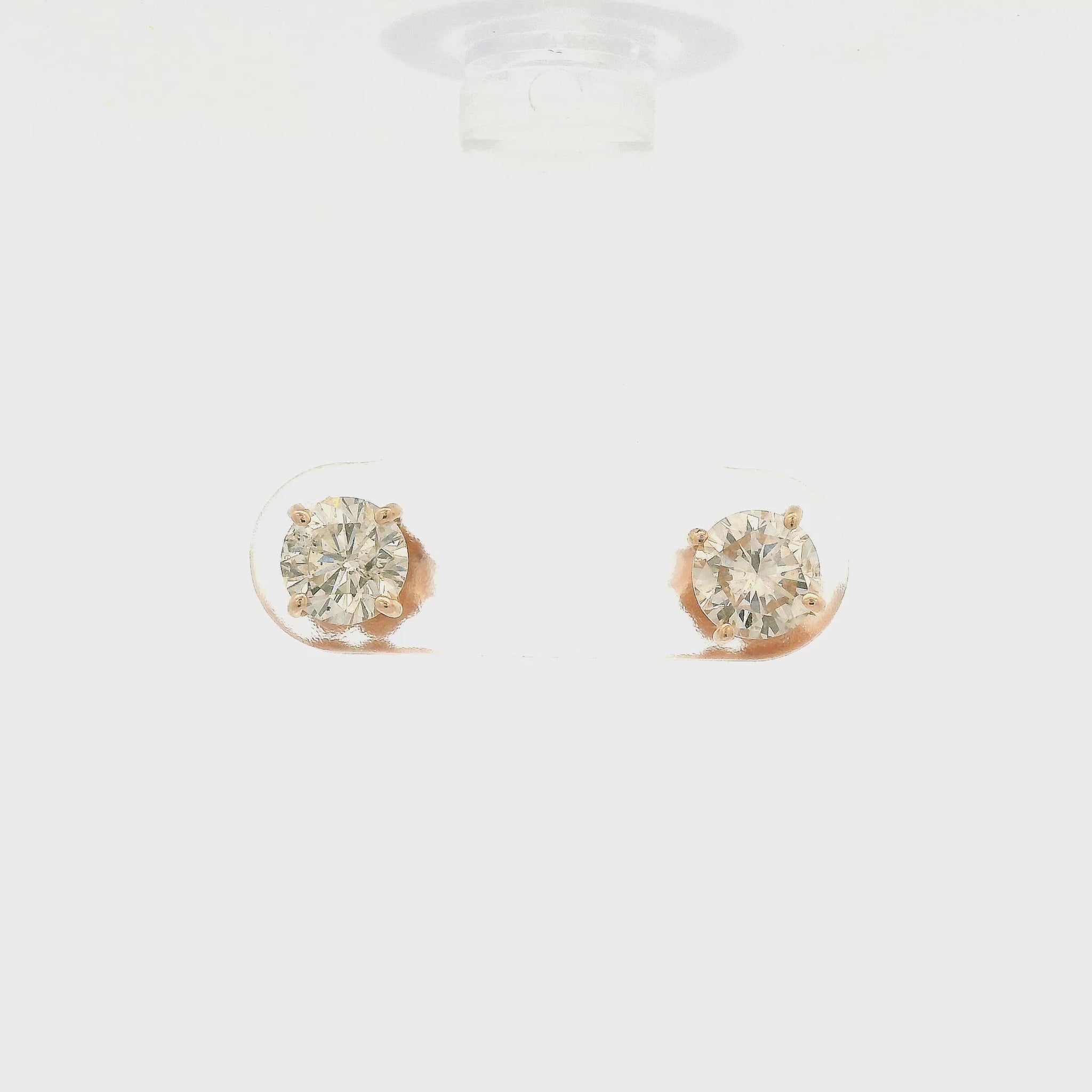 A Pair of round cut diamond studs with I1 clarity and totaling 1.10cts of diamonds set in 4 prong rose gold stud settings at Forever Rox Fine Jewelry