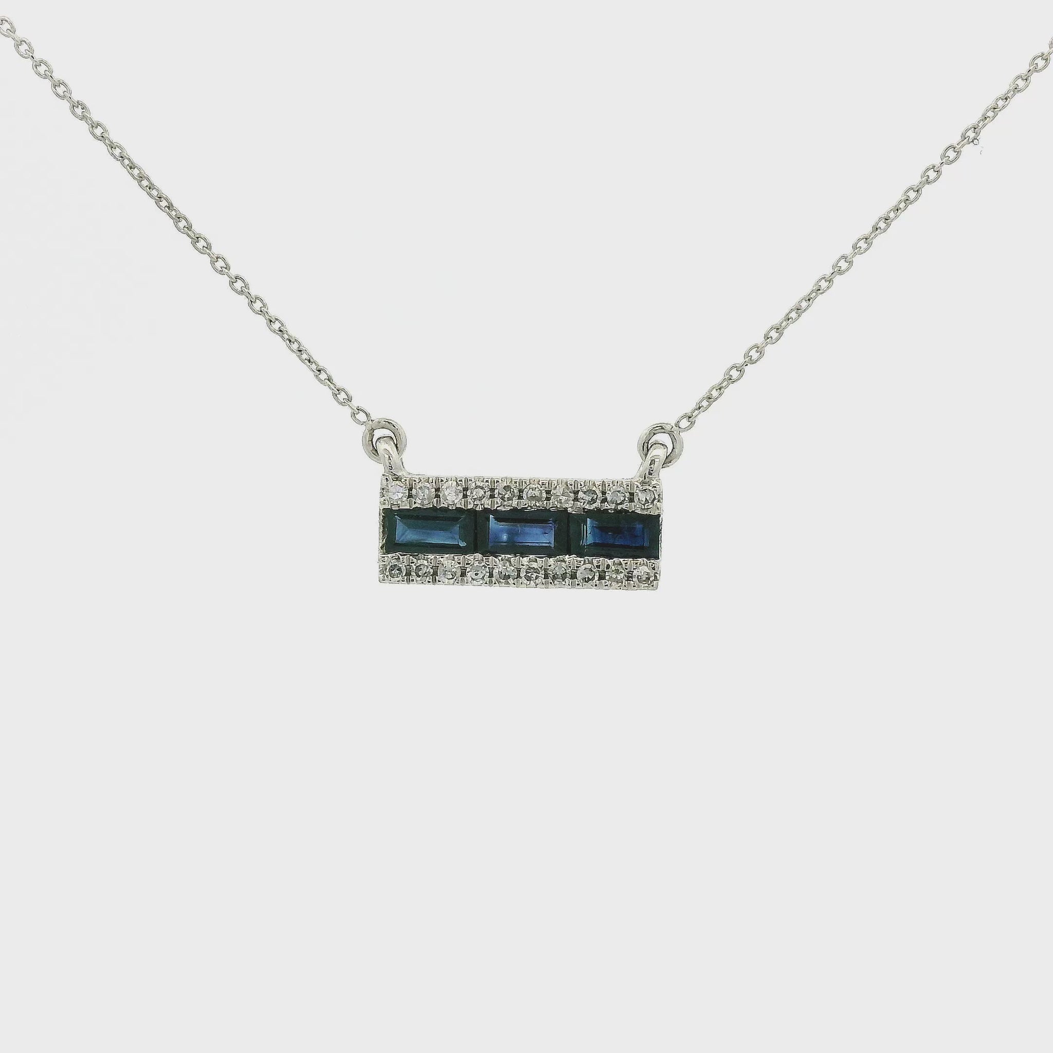 A White Gold Pendant with three channel set fancy cut baguette cut Naural Sapphires in the center and diamonds on the top and bottom of them with a chain attached at Forever Rox Fine Jewelry, Lake Tahoes Best Jewelry Store