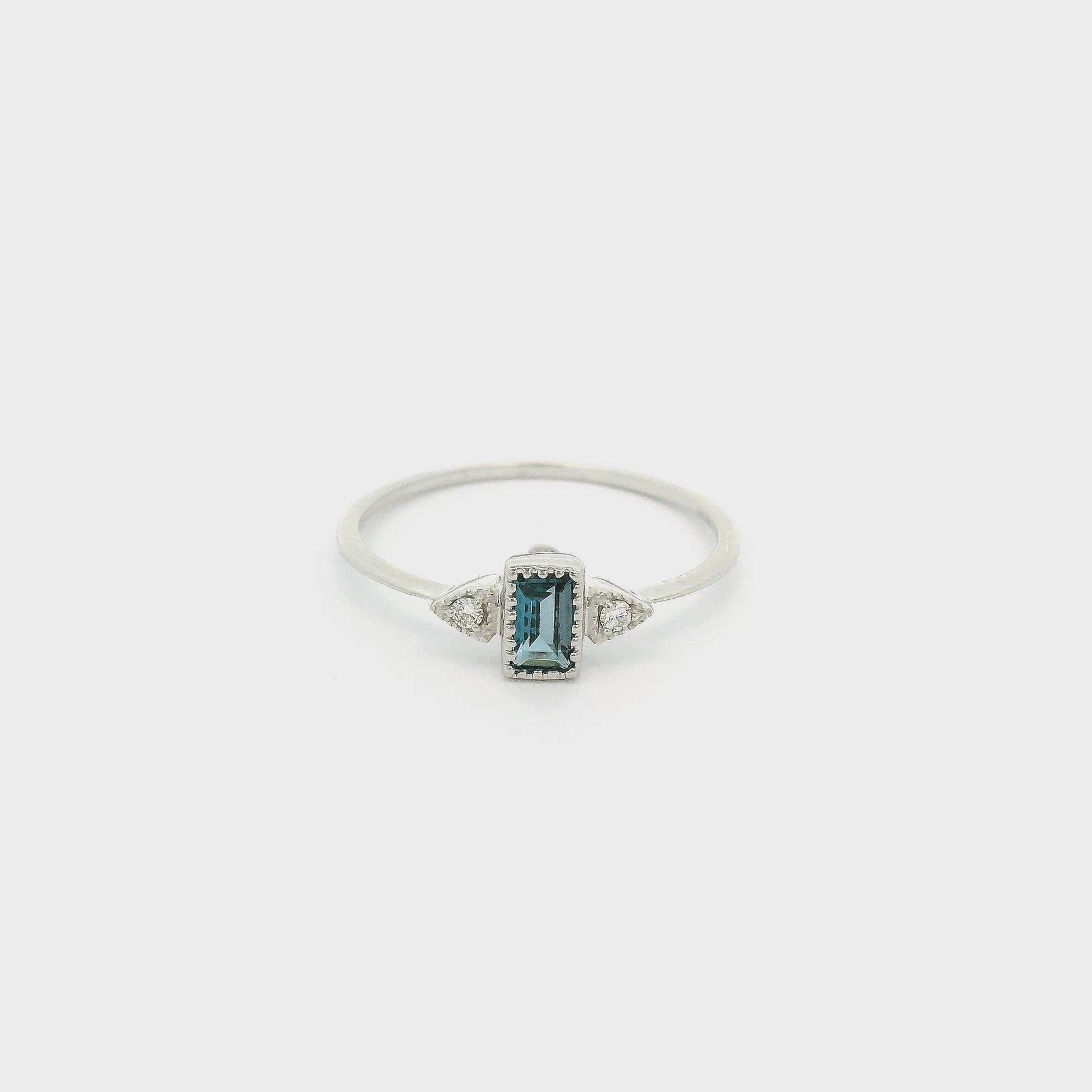 A White Gold Ring with a bezel set emerald cut Sapphire in the center with a milgrain bezel and one diamond on each side at Forever Rox Fine Jewelry, Lake Tahoes Best Jewelry Store