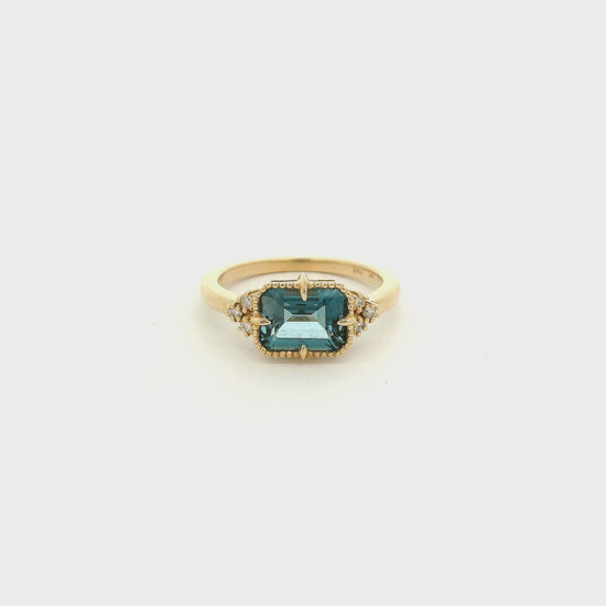 A Yellow Gold Ring with a milgrain bezel set & claw rong emerald cut natural London BLue Topaz in the center with diamonds scattered at Forever Rox Fine Jewelry, Lake Tahoes Best Jewelry Store
