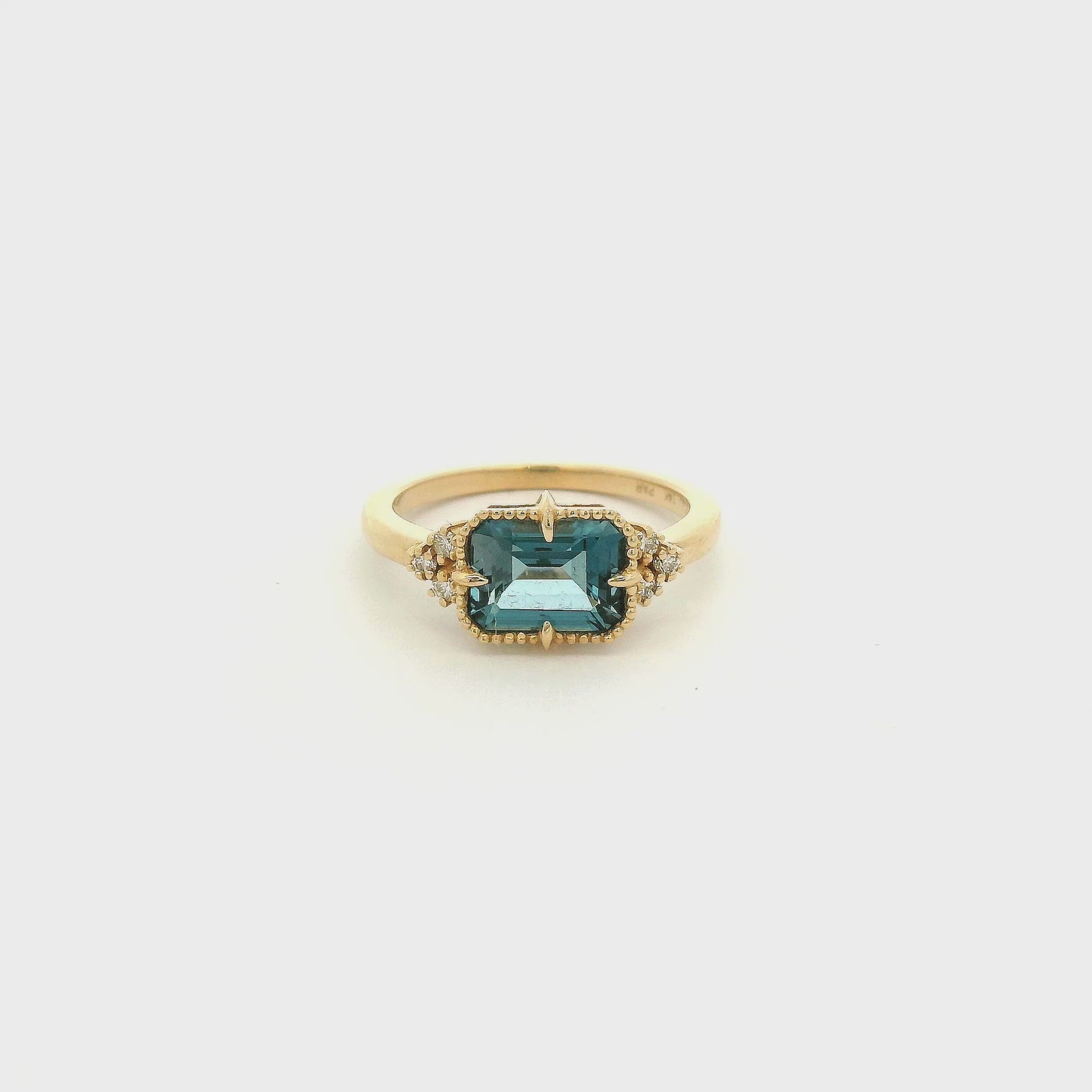 A Yellow Gold Ring with a milgrain bezel set & claw rong emerald cut natural London BLue Topaz in the center with diamonds scattered at Forever Rox Fine Jewelry, Lake Tahoes Best Jewelry Store
