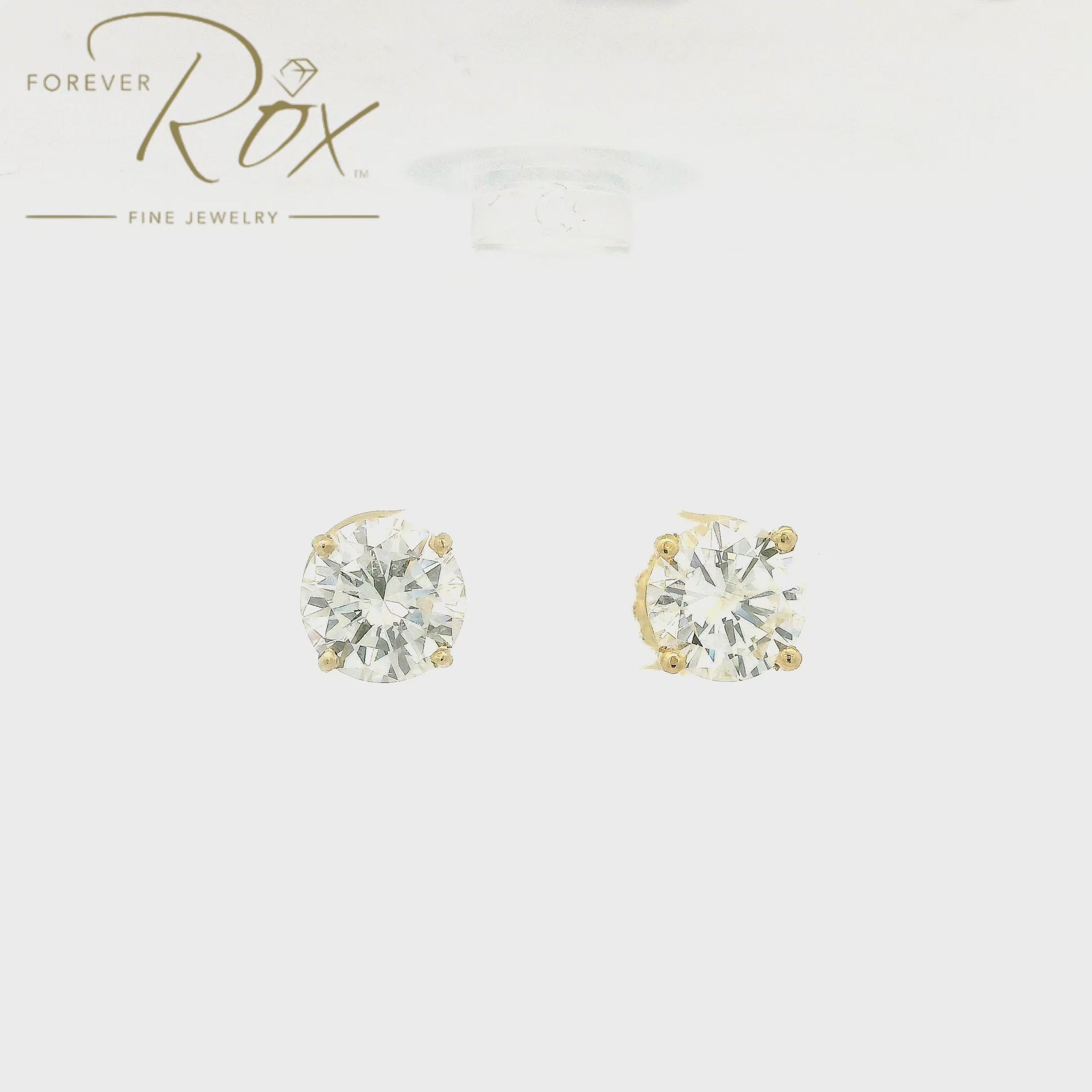 A pair of diamond studs set in yellow gold 4 prong stud earring mountings made at Forever Rox Fine Jewelry