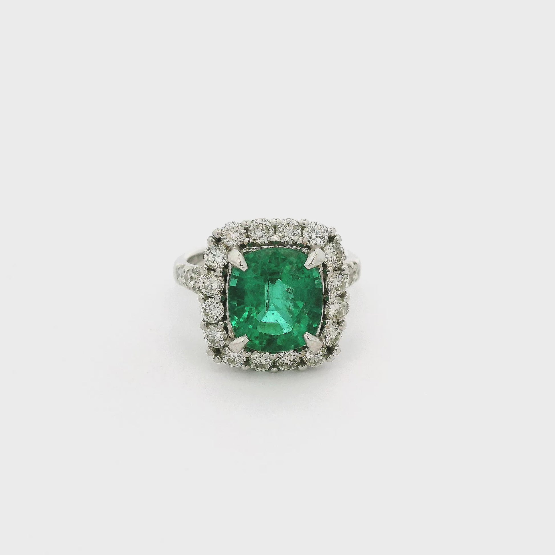 A White Gold Ring with a prong set cushion cut natural Emerald in the center with a diamond halo & diamonds down the shank at Forever Rox Fine Jewelry, Lake Tahoes Best Jewelry Store