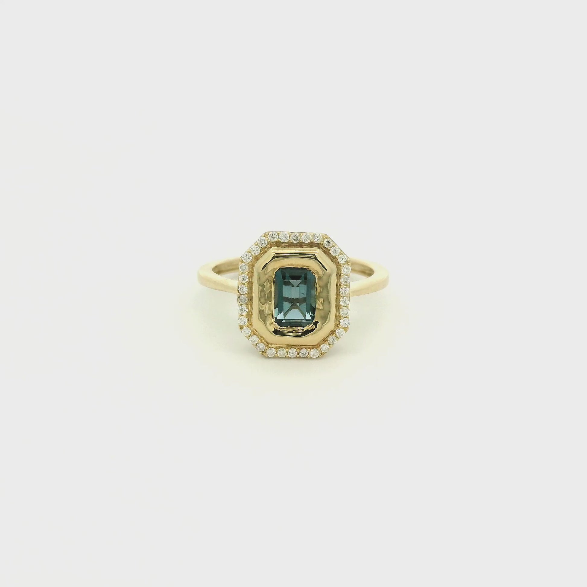 A Yellow Gold Ring with a bezel set emerald cut natural London Blue Topaz in the center with diamonds around the outside at Forever Rox Fine Jewelry, Lake Tahoes Best Jewelry Store
