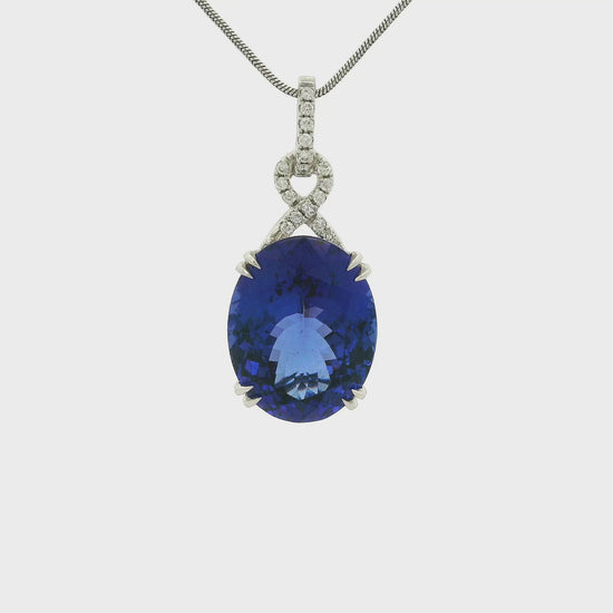 A White Gold Pendant with a prong set oval cut natural Tanzanite in the center with diamonds in an infinity shape above at Forever Rox Fine Jewelry, Lake Tahoes Best Jewelry Store