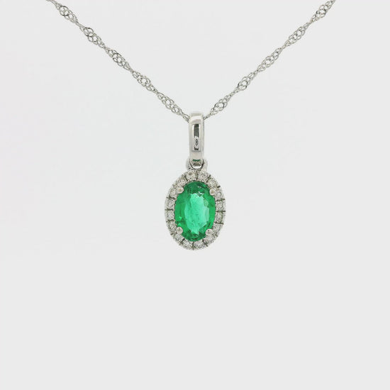 A White Gold Pendant with a prong set oval cut Emerald in the center with a diamond halo around it at Forever Rox Fine Jewelry, Lake Tahoes Best Jewelry Store