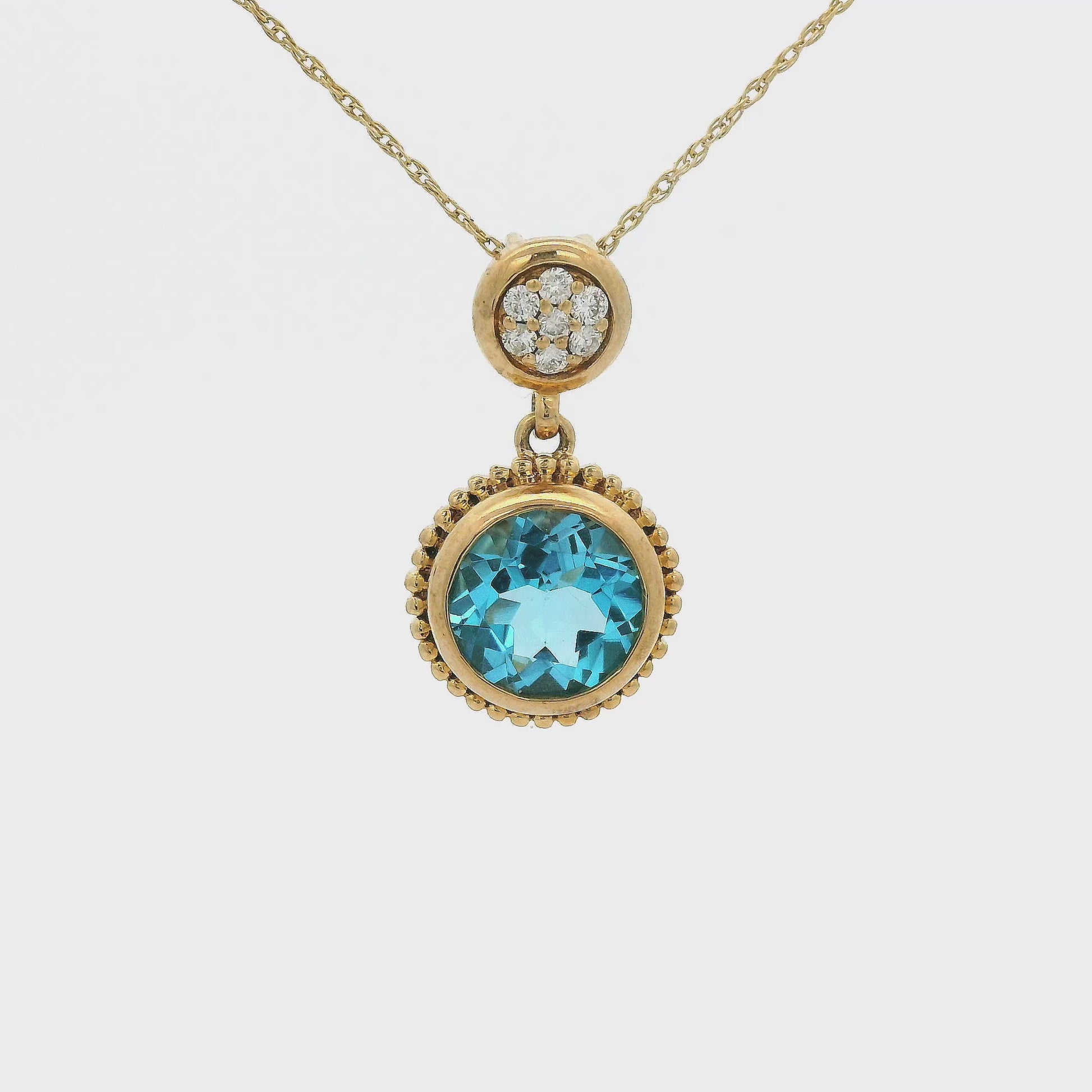 A Yellow Gold Pendant with a bezel set round cut natural Blue Topaz in the center with diamond circle bail at Forever Rox Fine Jewelry, Lake Tahoes Best Jewelry Store
