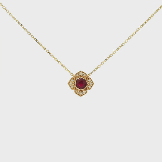 A Yellow Gold Flower Pendant with a milgrain bezel set round cut natural Ruby in the centerand diamonds with a chain attached at Forever Rox Fine Jewelry, Lake Tahoes Best Jewelry Store