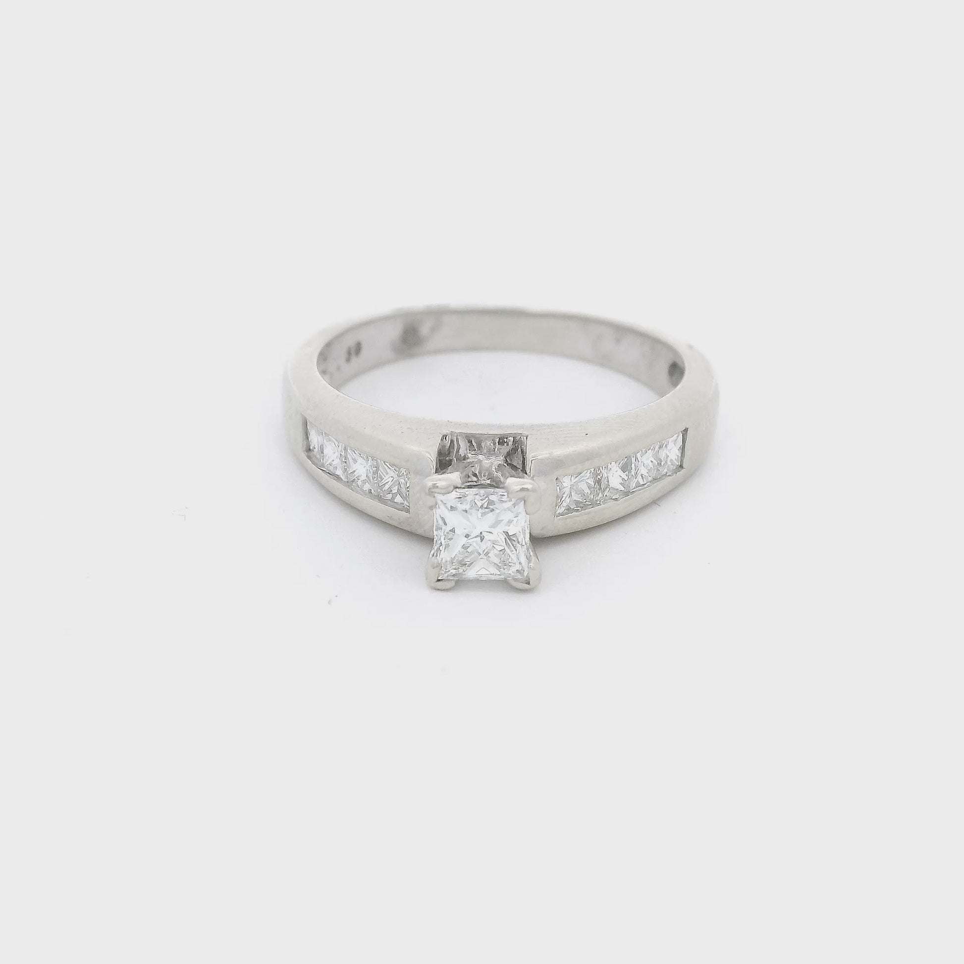 White Gold ring with a princess cut diaond in the center and four princess cut diamonds channel set down each shank at Forever Rox Fine Jewelry 
