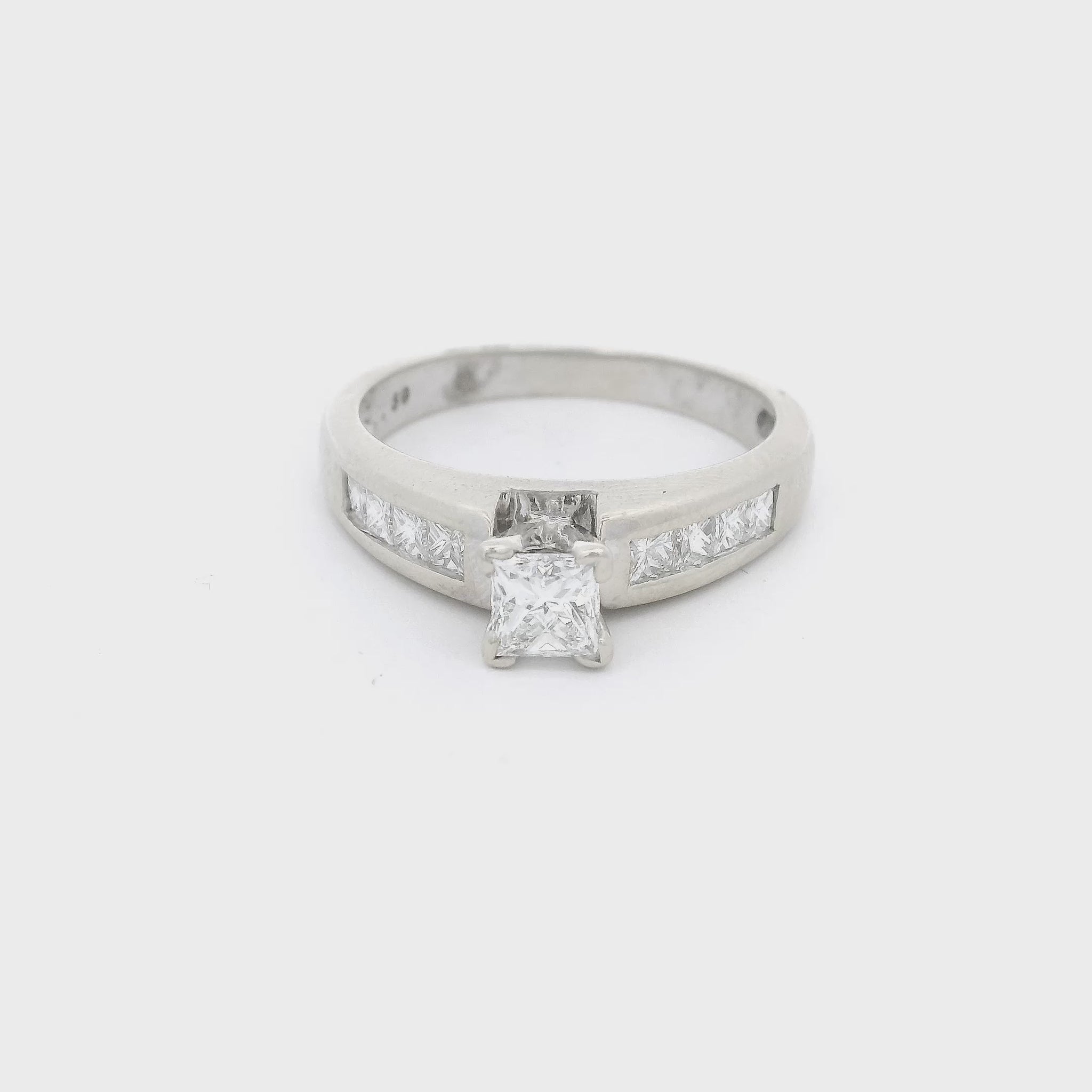 White Gold ring with a princess cut diaond in the center and four princess cut diamonds channel set down each shank at Forever Rox Fine Jewelry 
