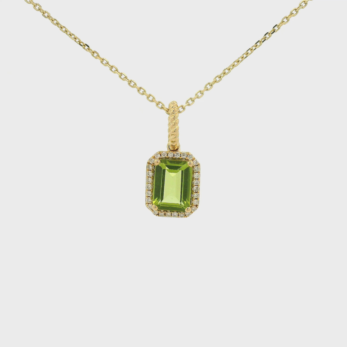 A Yellow Gold Pendant with a prong set emerald cut natural Peridot in the center with a diamond halo at Forever Rox Fine Jewelry, Lake Tahoes Best Jewelry Store
