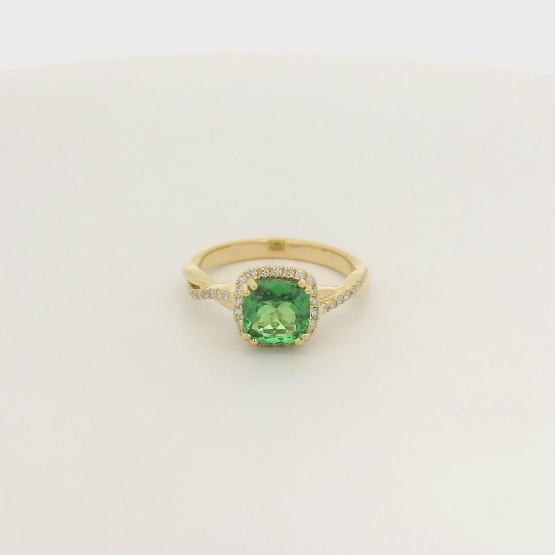 A Yellow Gold Crossover Ring with a prong set cushion cut natural Tsavorite in the center with a halo of diamonds and diamonds down shank at Forever Rox Fine Jewelry, Lake Tahoes Best Jewelry Store