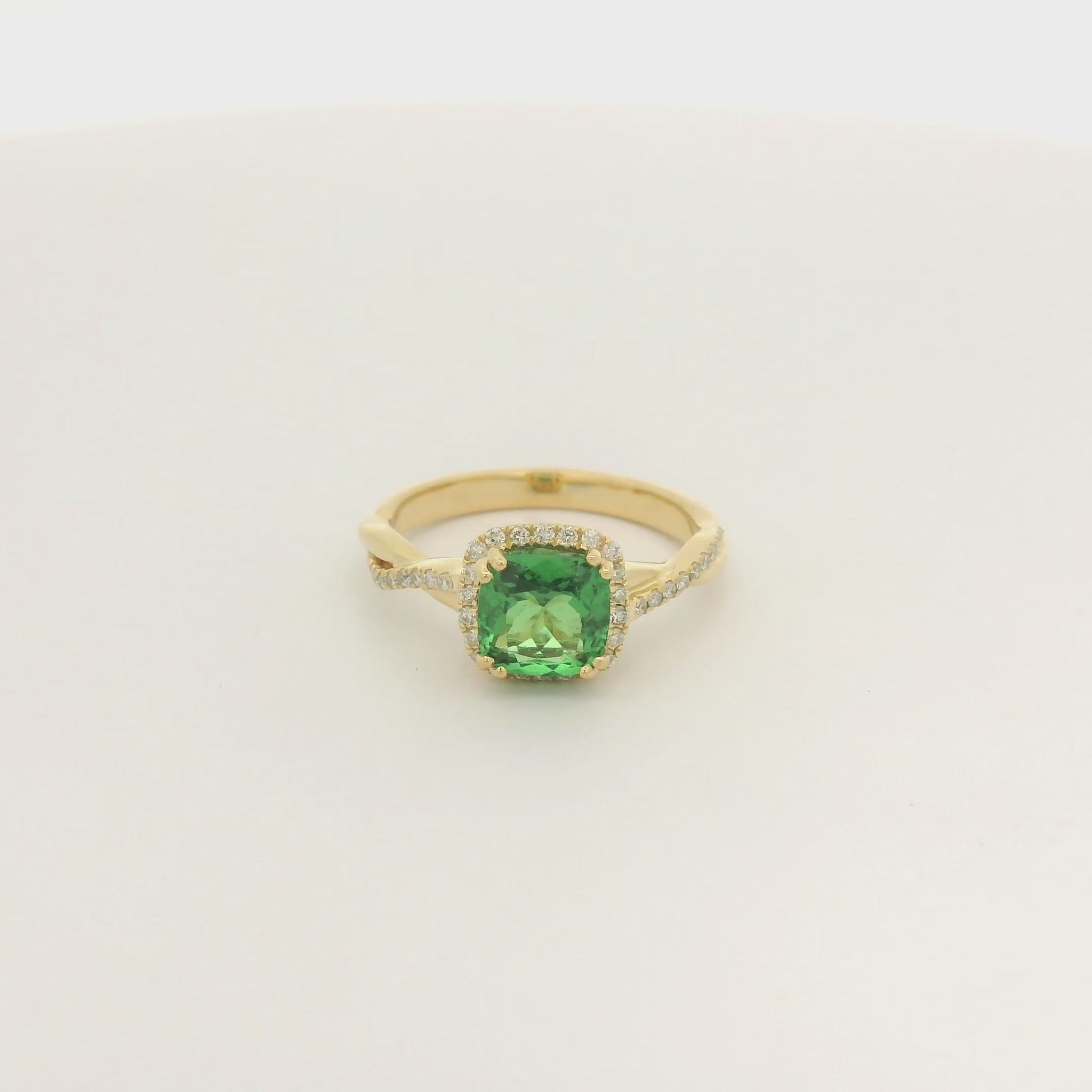 A Yellow Gold Crossover Ring with a prong set cushion cut natural Tsavorite in the center with a halo of diamonds and diamonds down shank at Forever Rox Fine Jewelry, Lake Tahoes Best Jewelry Store