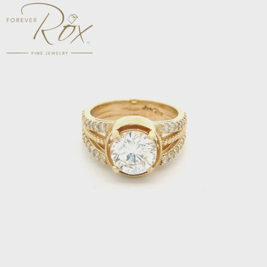 Yellow Gold ring with one center cut round diamond and a shank that splits into three with the outsides having diamonds and the center having a milgrain design at Forever Rox Fine Jewelry