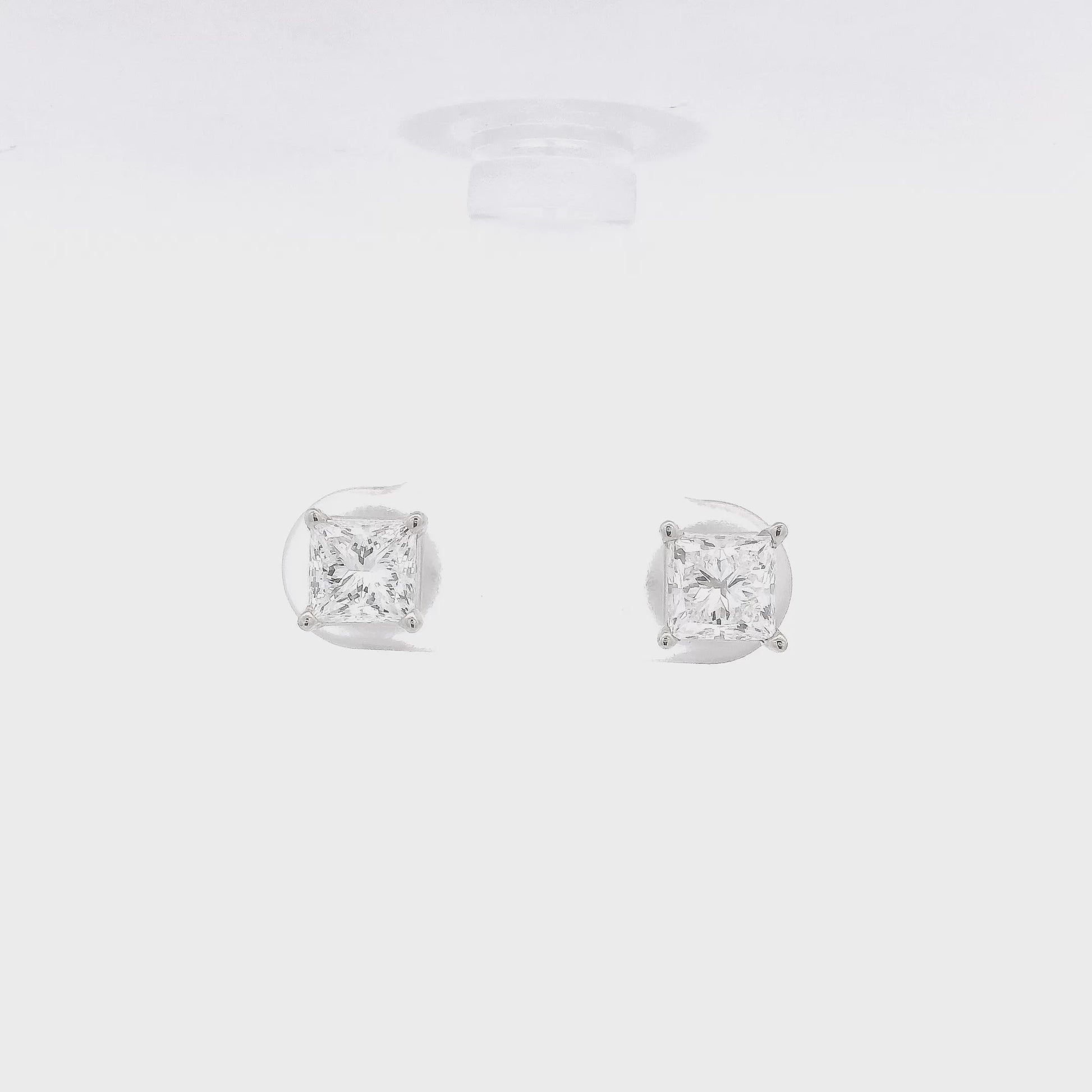 A pair of 4 Prong White Gold Studs with 1.51ctw of princess cut diamonds set in the earrings at Forever Rox Fine Jewelry
