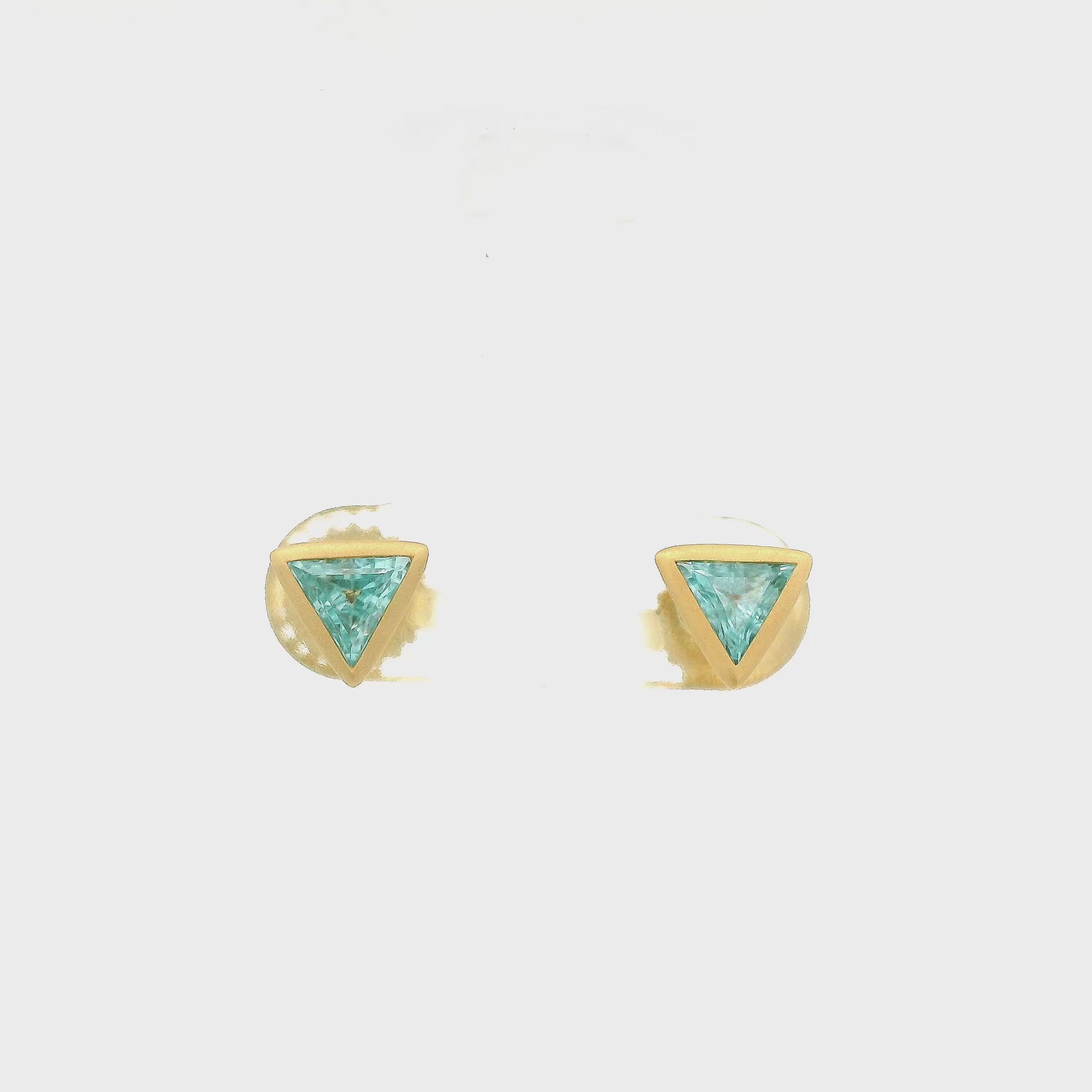 A Pair of Yellow Gold Studs with bezel set triangle cut Blue Zircons in the center at Lake Tahoes best Jewelry Store, Forever Rox Fine Jewelry