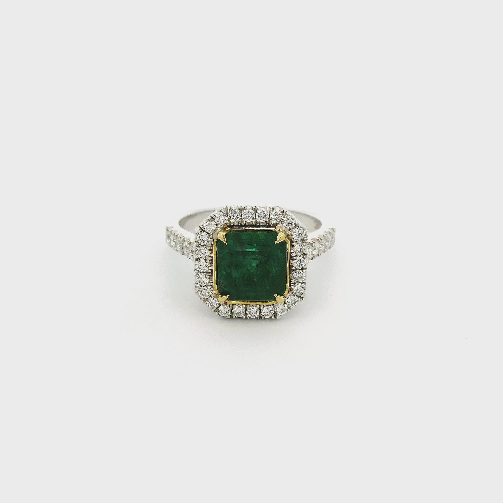A White Gold Ring with a prong set square emerald cut Emerald in the center with a halo of diamonds and diamonds down shank at Forever Rox Fine Jewelry, Lake Tahoes Best Jewelry Store