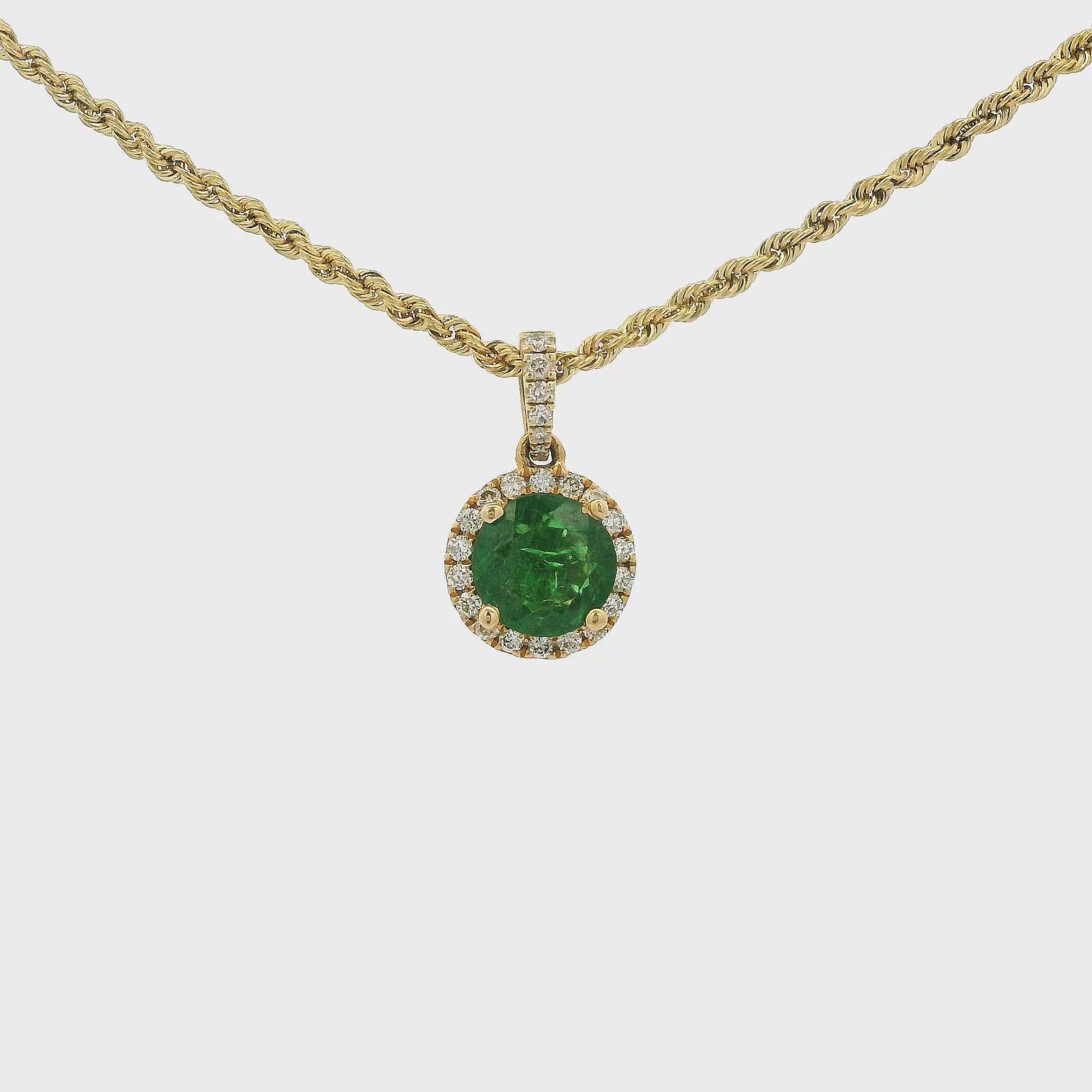 A Yellow Gold Pendant with a prong set round cut natural Tsavorite Garnet in the center with a halo of diamonds and diamond bail at Forever Rox Fine Jewelry, Lake Tahoes Best Jewelry Store.