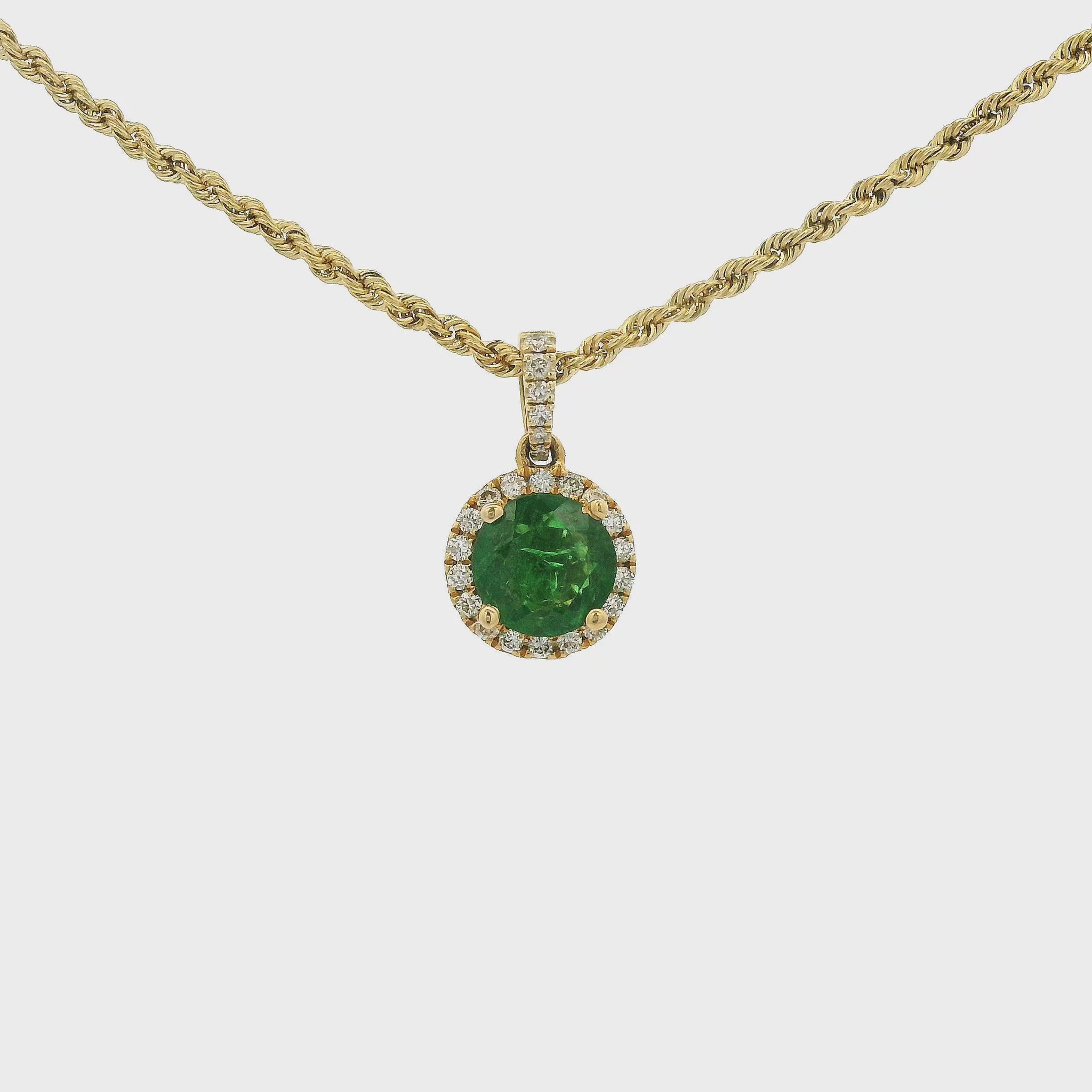 A Yellow Gold Pendant with a prong set round cut natural Tsavorite Garnet in the center with a halo of diamonds and diamond bail at Forever Rox Fine Jewelry, Lake Tahoes Best Jewelry Store.