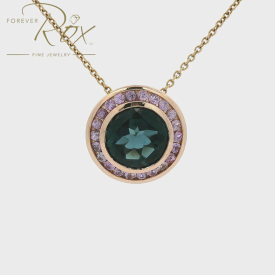 A striking 4.31ct round-cut London Blue Topaz takes center stage in this custom 14k rose gold pendant, framed by a delicate halo of light purple sapphires for an unexpected pop of color. Crafted to complement a client's existing ring, the warm rose gold setting reveals an intricate filigree gallery along its sides — a hidden detail that elevates every angle. Bold yet refined, it's a modern heirloom designed to be worn and treasured.