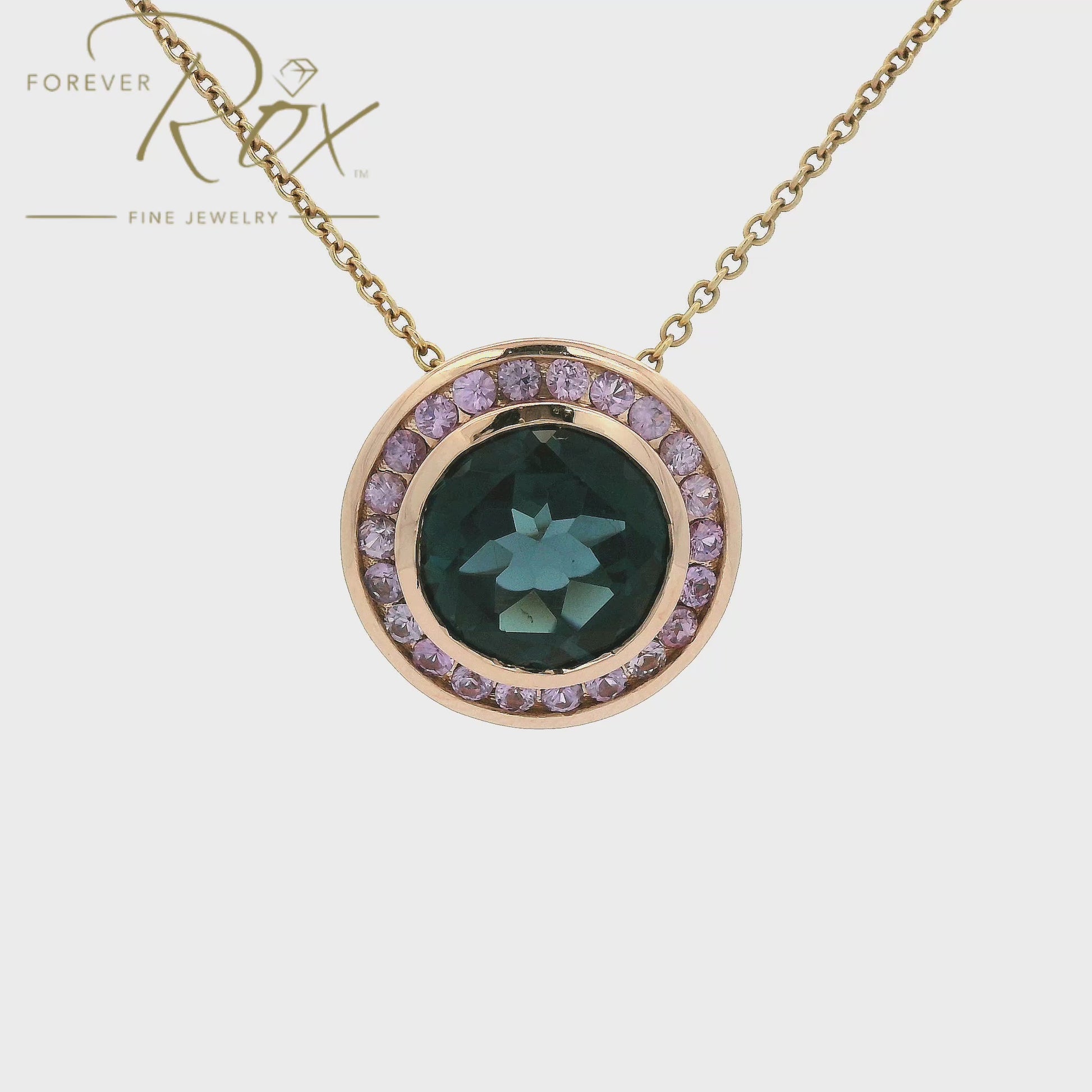 A striking 4.31ct round-cut London Blue Topaz takes center stage in this custom 14k rose gold pendant, framed by a delicate halo of light purple sapphires for an unexpected pop of color. Crafted to complement a client's existing ring, the warm rose gold setting reveals an intricate filigree gallery along its sides — a hidden detail that elevates every angle. Bold yet refined, it's a modern heirloom designed to be worn and treasured.