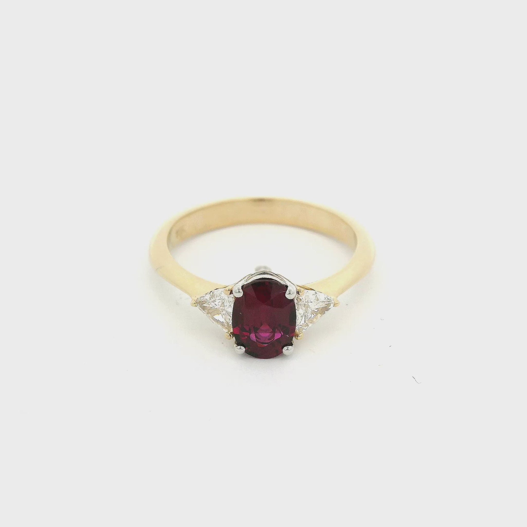 A Yellow Gold Ring with a prong set oval cut natural Certified No Heat Ruby in the center with two triangle cut diamonds on the side at Forever Rox Fine Jewelry, Lake Tahoes Best Jewelry Store
