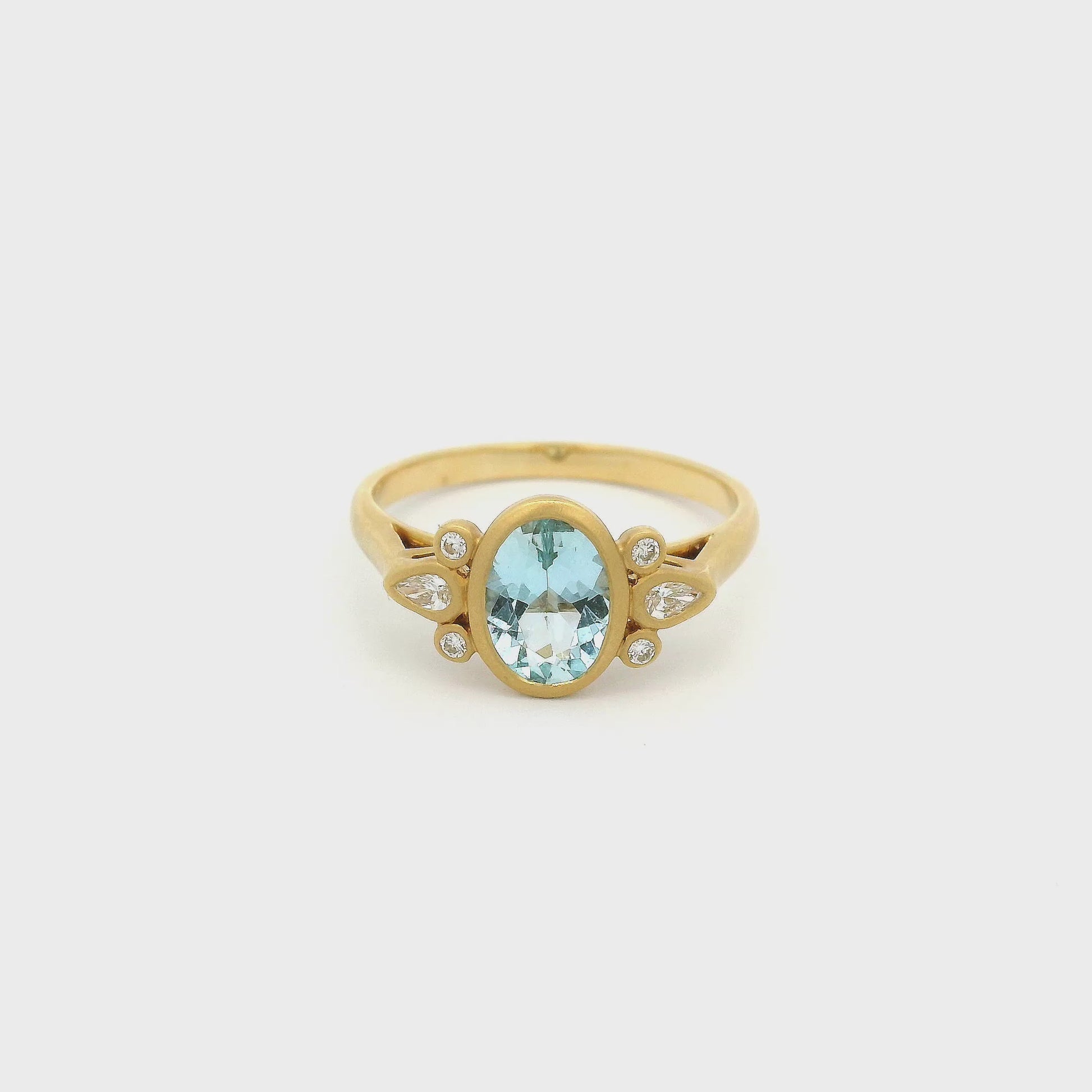 A Yellow Gold Ring with a bezel set oval cut Aquamarine in the center with two round cut and one pear cut diamond on each side - Lake Tahoes  Best Jewelry Store, Forever Rox Fine Jewelry
