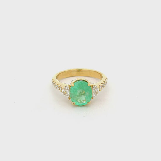 A Yellow Gold Ring with a prong set oval cut natural Green Paraíba Tourmaline in the center with two chevron cut diamonds next to it and diamonds down the shank at Forever Rox Fine Jewelry, Lake Tahoes Best Jewelry Store.