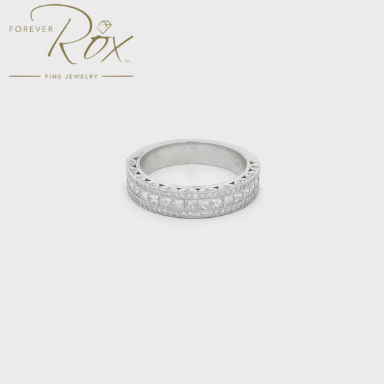 This custom platinum diamond band was designed to perfectly complement a client’s original ring that we previously created for her. The center features a row of channel-set princess-cut diamonds, framed above and below by channel-set round brilliant diamonds for added sparkle. Intricate filigree detailing along the edges was carefully incorporated to match the design of her original ring, creating a cohesive, one-of-a-kind set made especially for her.