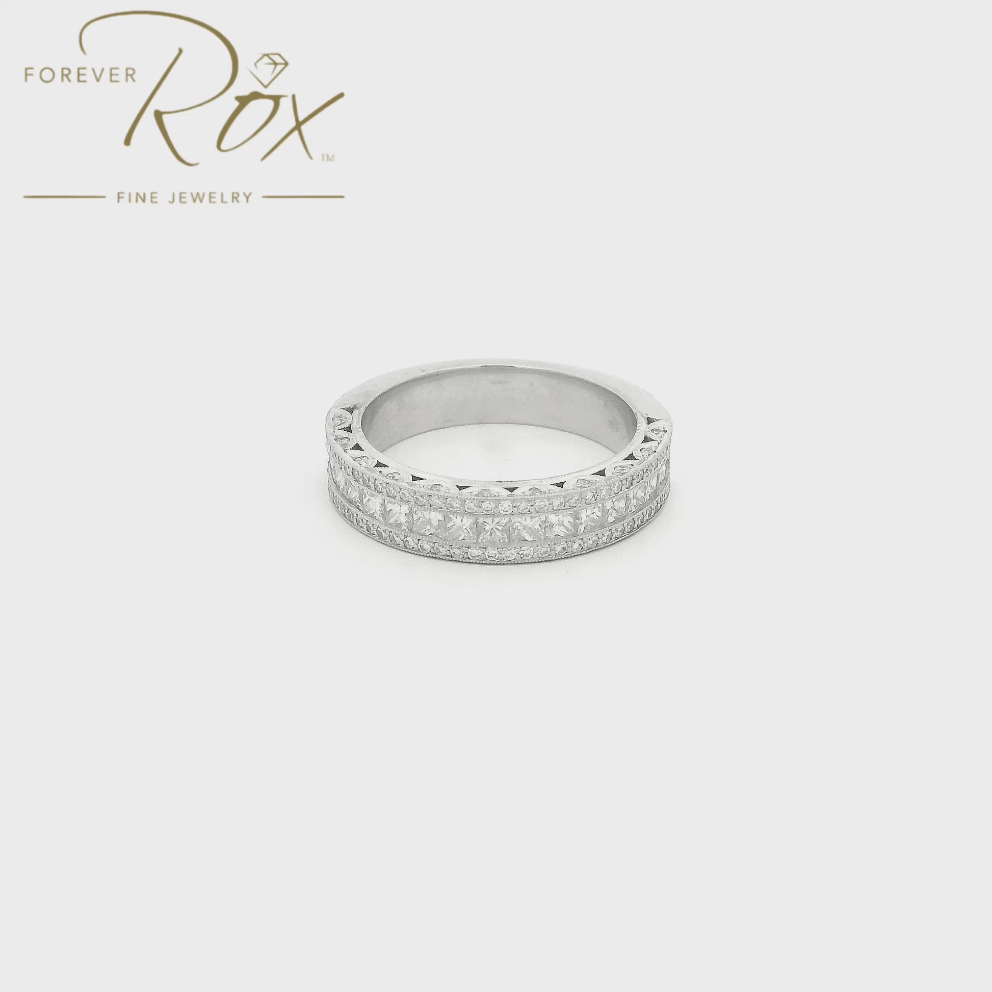 This custom platinum diamond band was designed to perfectly complement a client’s original ring that we previously created for her. The center features a row of channel-set princess-cut diamonds, framed above and below by channel-set round brilliant diamonds for added sparkle. Intricate filigree detailing along the edges was carefully incorporated to match the design of her original ring, creating a cohesive, one-of-a-kind set made especially for her.
