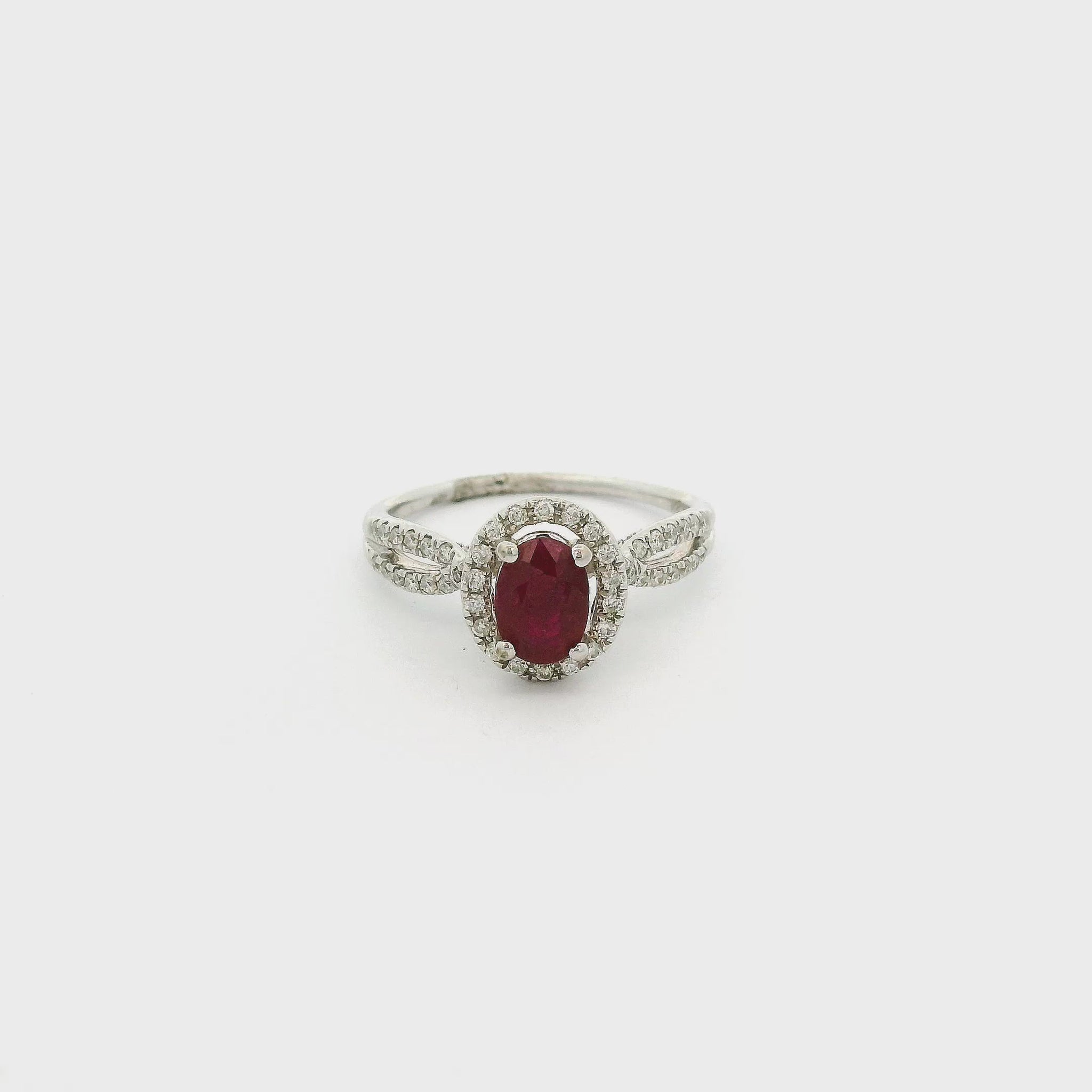 A White Gold Ring with a prong set oval cut natural Ruby in the center with a diamond halo and diamonds down the crossover shank at Forever Rox Fine Jewelry, Lake Tahoes Best Jewelry Store