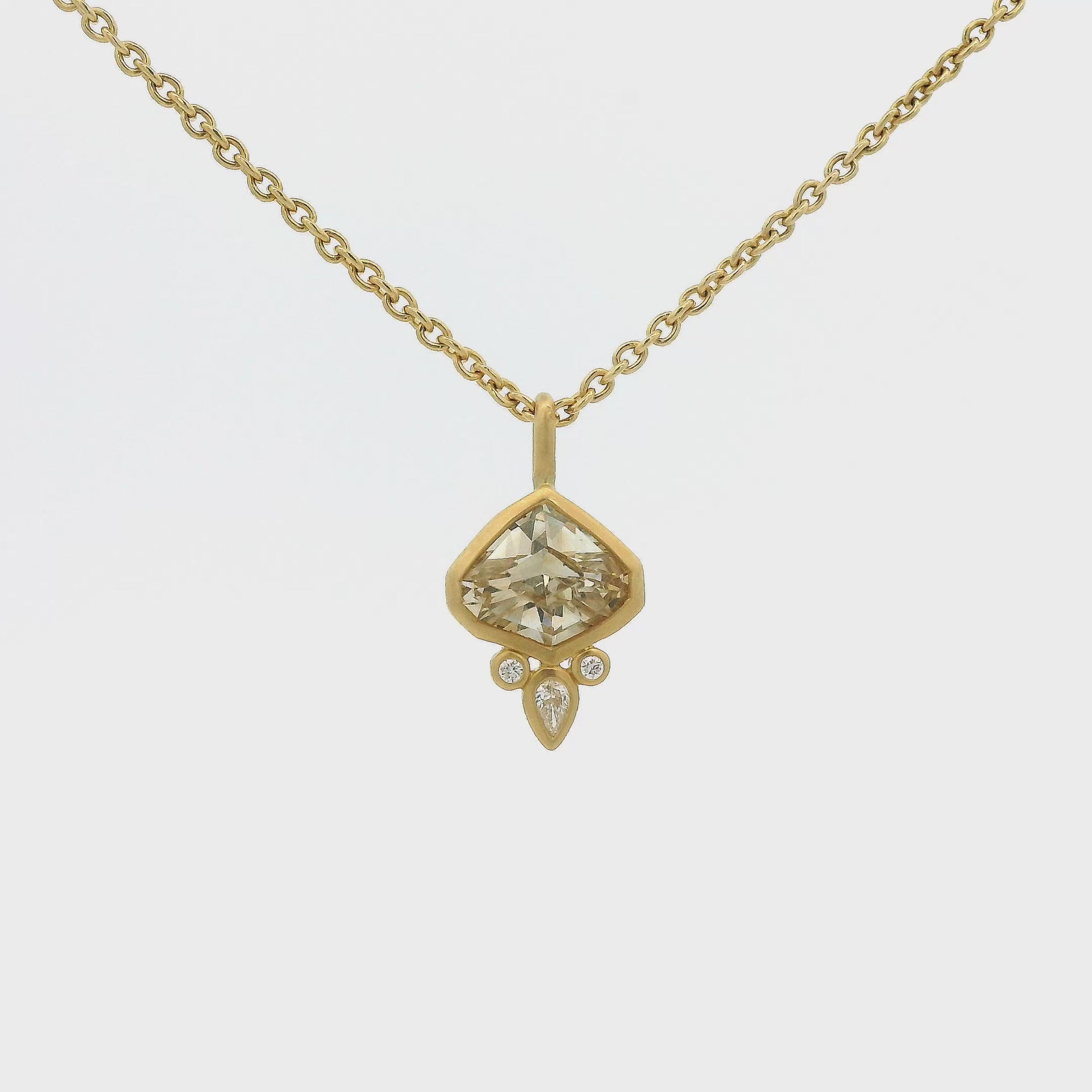 A Yellow Gold Pendant with a bezel set fancy cut natural Champagne Sapphire in the center with 3 natural diamonds at Forever Rox Fine Jewelry, Lake Tahoes Best Jewelry Store