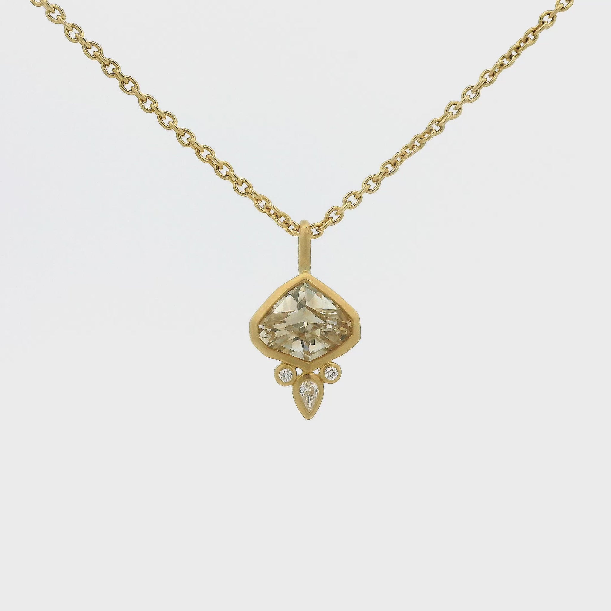 A Yellow Gold Pendant with a bezel set fancy cut natural Champagne Sapphire in the center with 3 natural diamonds at Forever Rox Fine Jewelry, Lake Tahoes Best Jewelry Store