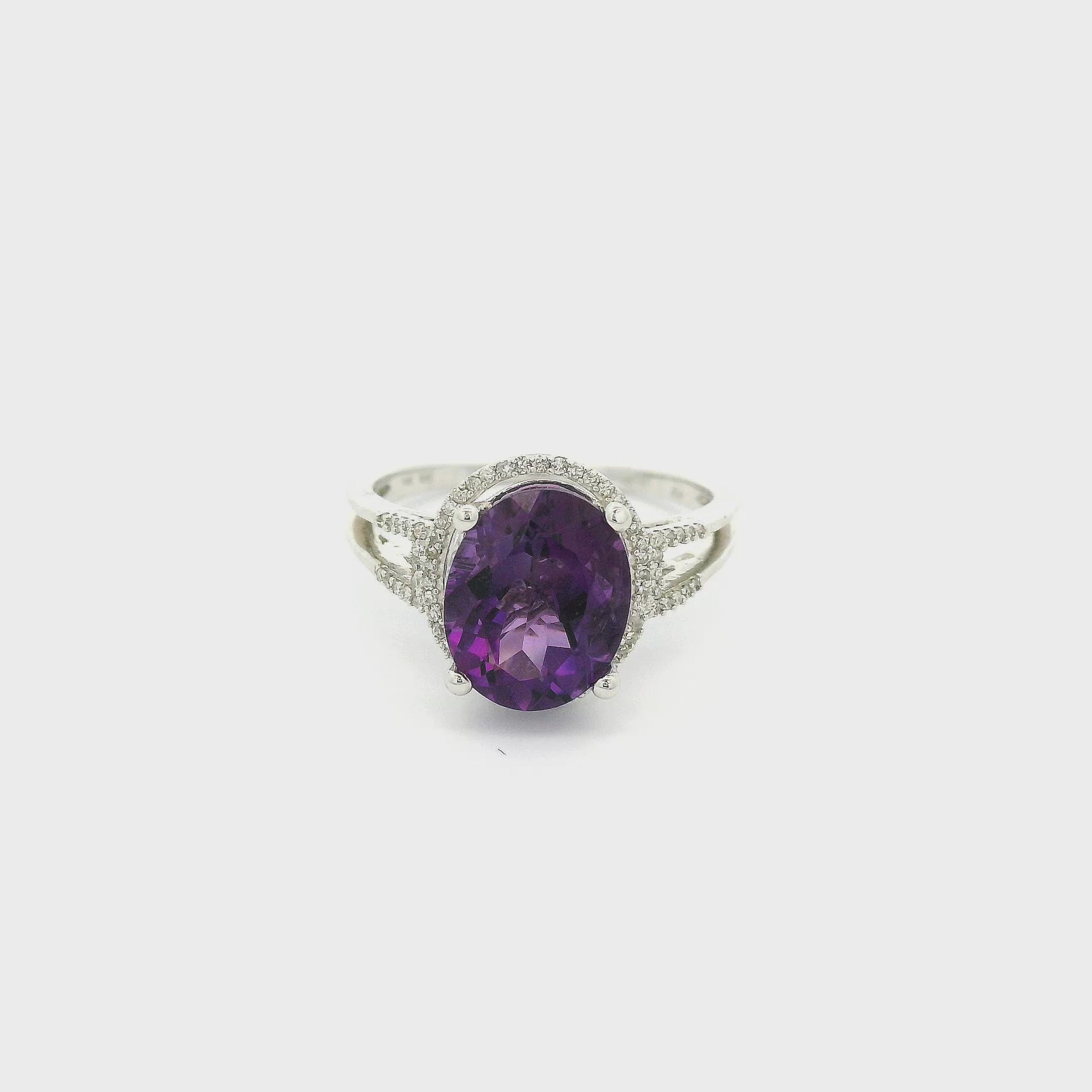 A White Gold Ring with a prong set oval cut Amethyst in the center with a halo of diamonds around it and diamonds down the split shank at Forever Rox Fine Jewelry, Lake Tahoes Best Jewelry Store